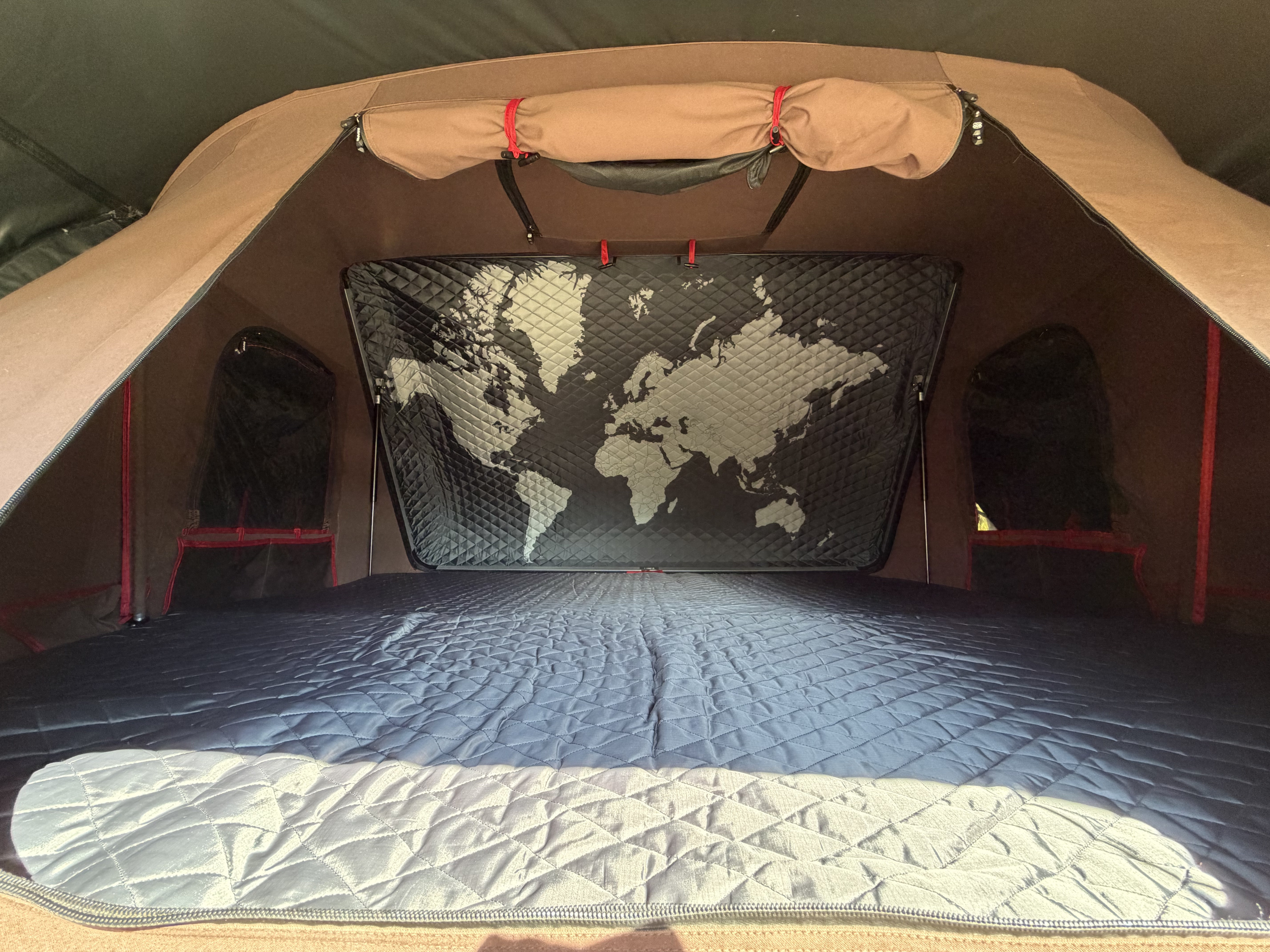 Inside a rooftop tent for your rv rental adventure: quilted mattress, world map, and cozy setup for travel.. Toyota 4Runner 2017