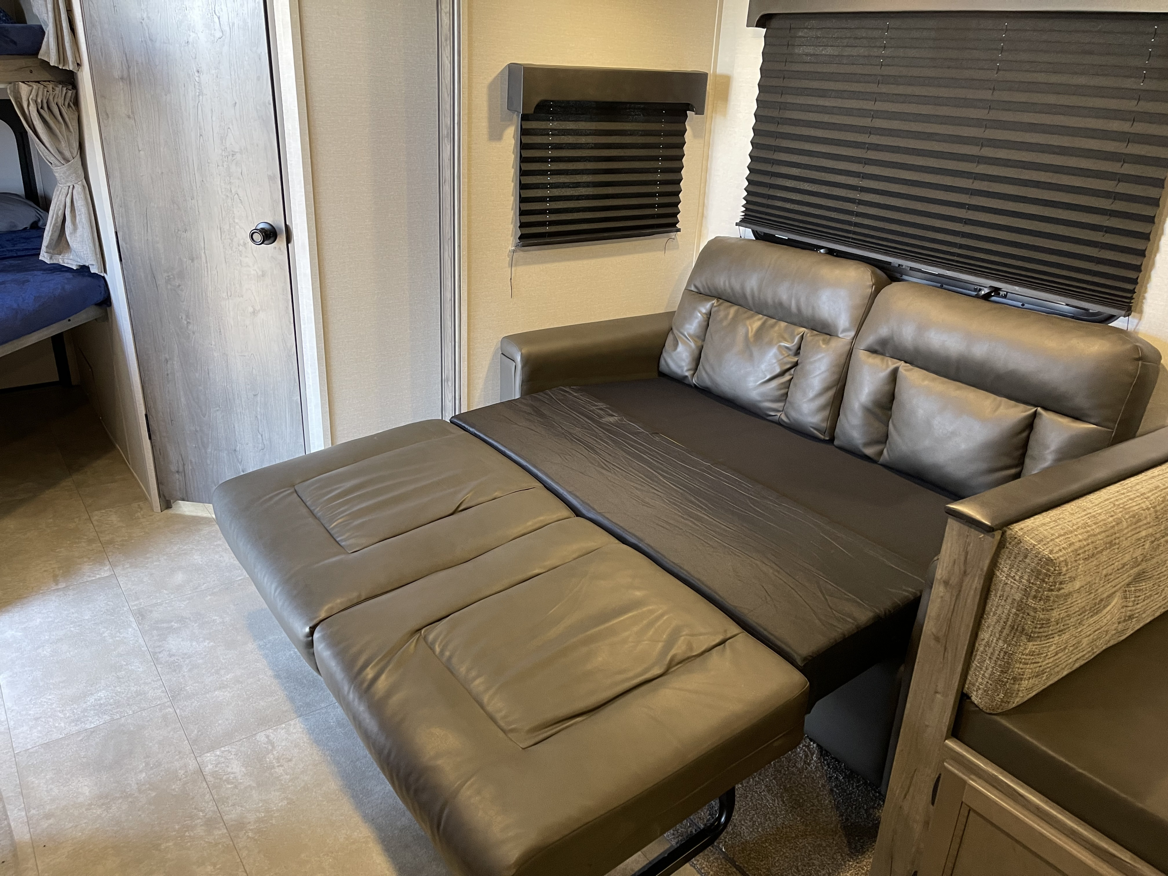 Experience comfort in this RV rental! Interior features a pull-out sofa bed, bunk beds, and dark window blinds.. Coachmen Apex 2021