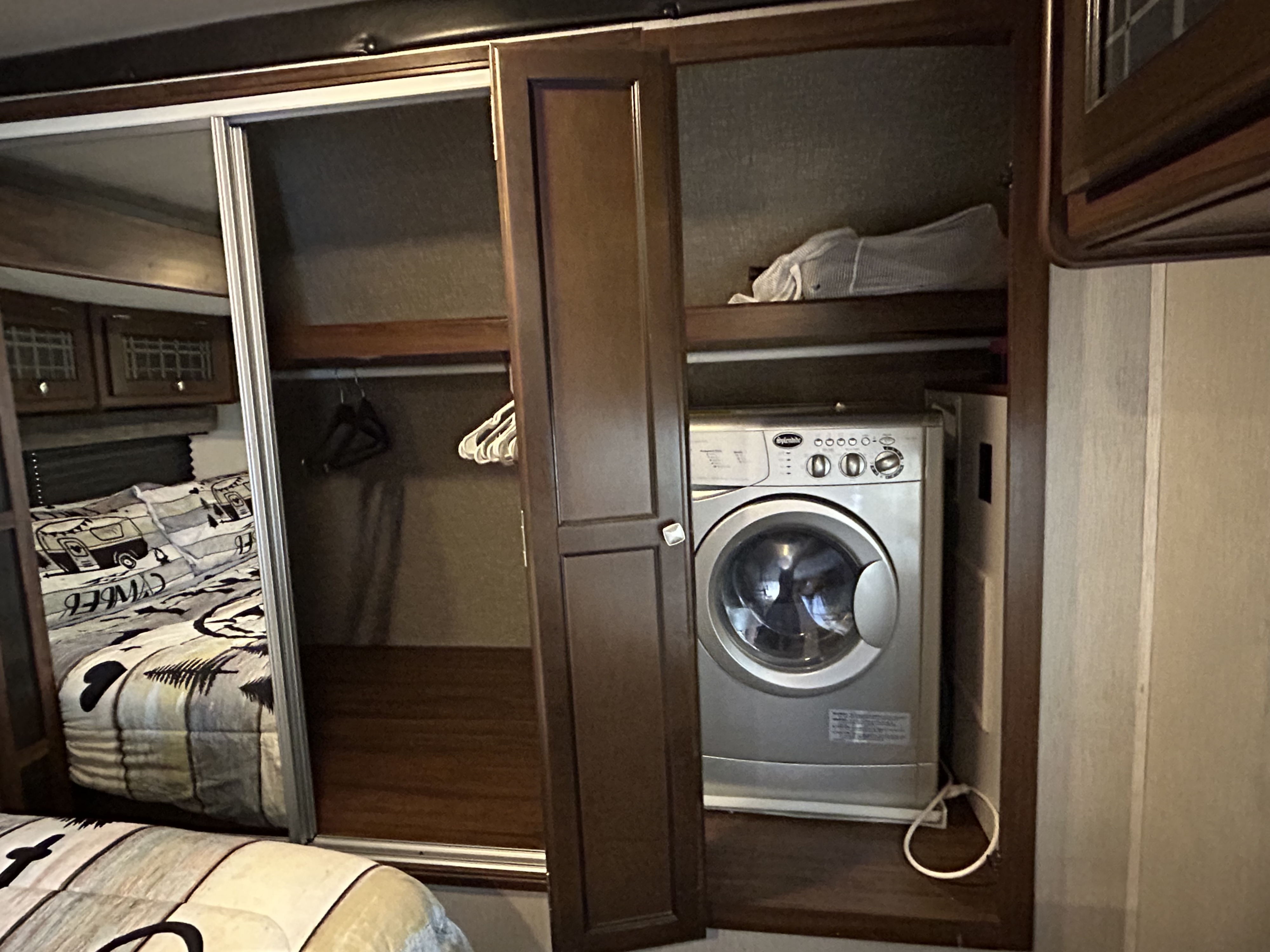 RV rental with a compact washer dryer unit neatly integrated into the bedroom closet, offering convenience and storage.. Heartland RVs Mallard 2019