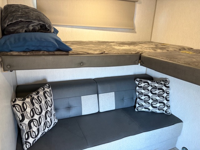 This RV rental offers L-shaped bunk beds & a comfortable seating area. Ideal for compact travel and family comfort on the road.. Forest River Wildwood 2023