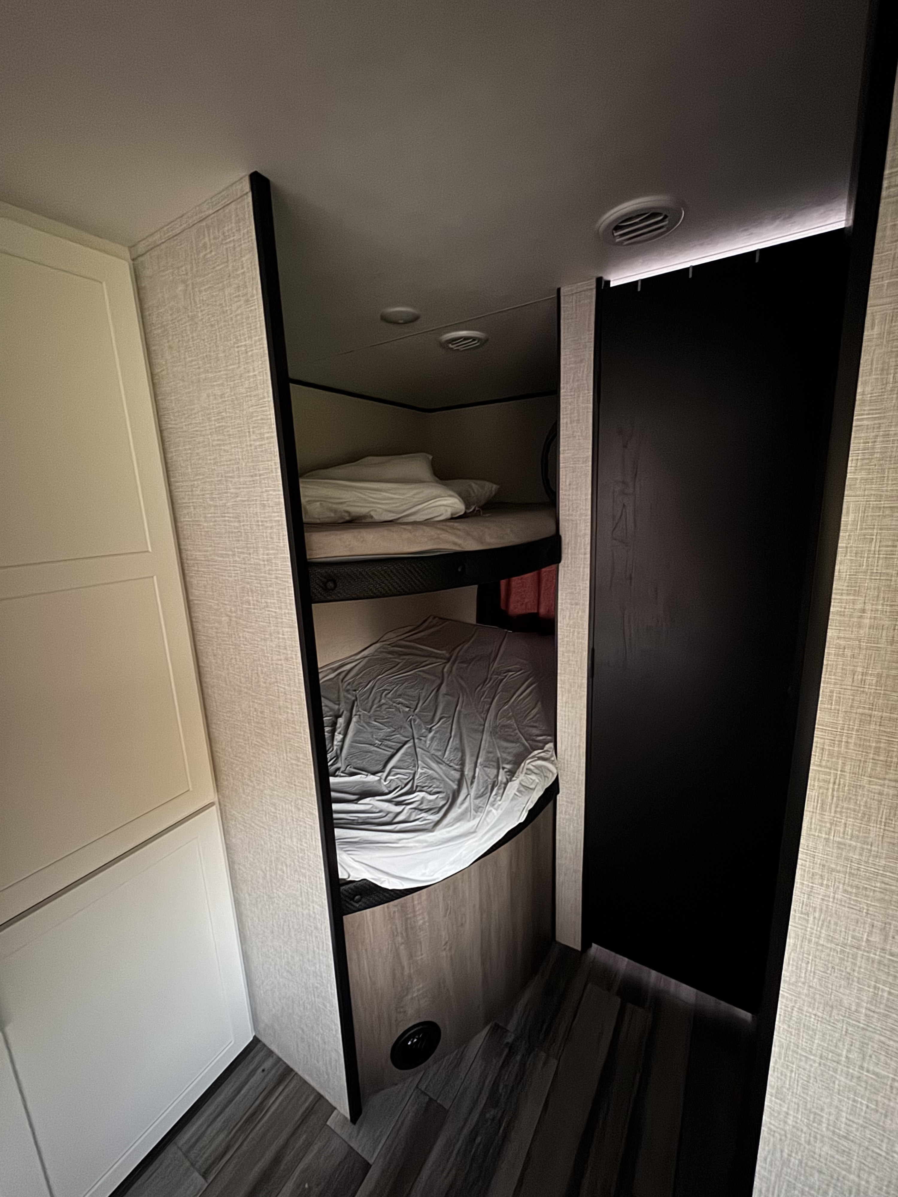 Cozy bunk beds in an RV rental for family camping. Features textured walls & dark floor.. Jayco Jay Flight SLX 2025