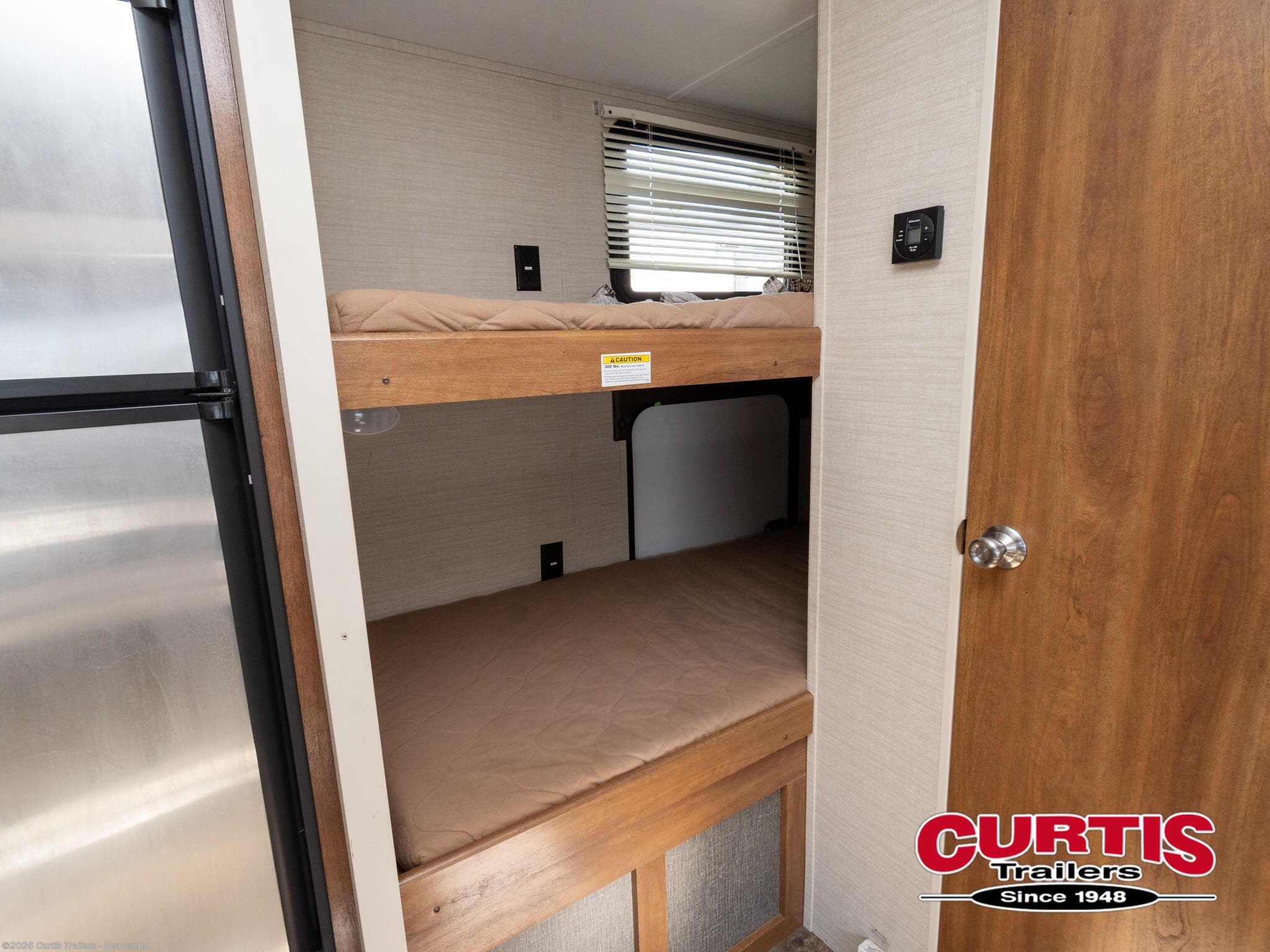 Inside an RV rental: cozy bunk beds, window with blinds, fridge, and control panel for your next adventure.. Springdale sm2820bh16 2016