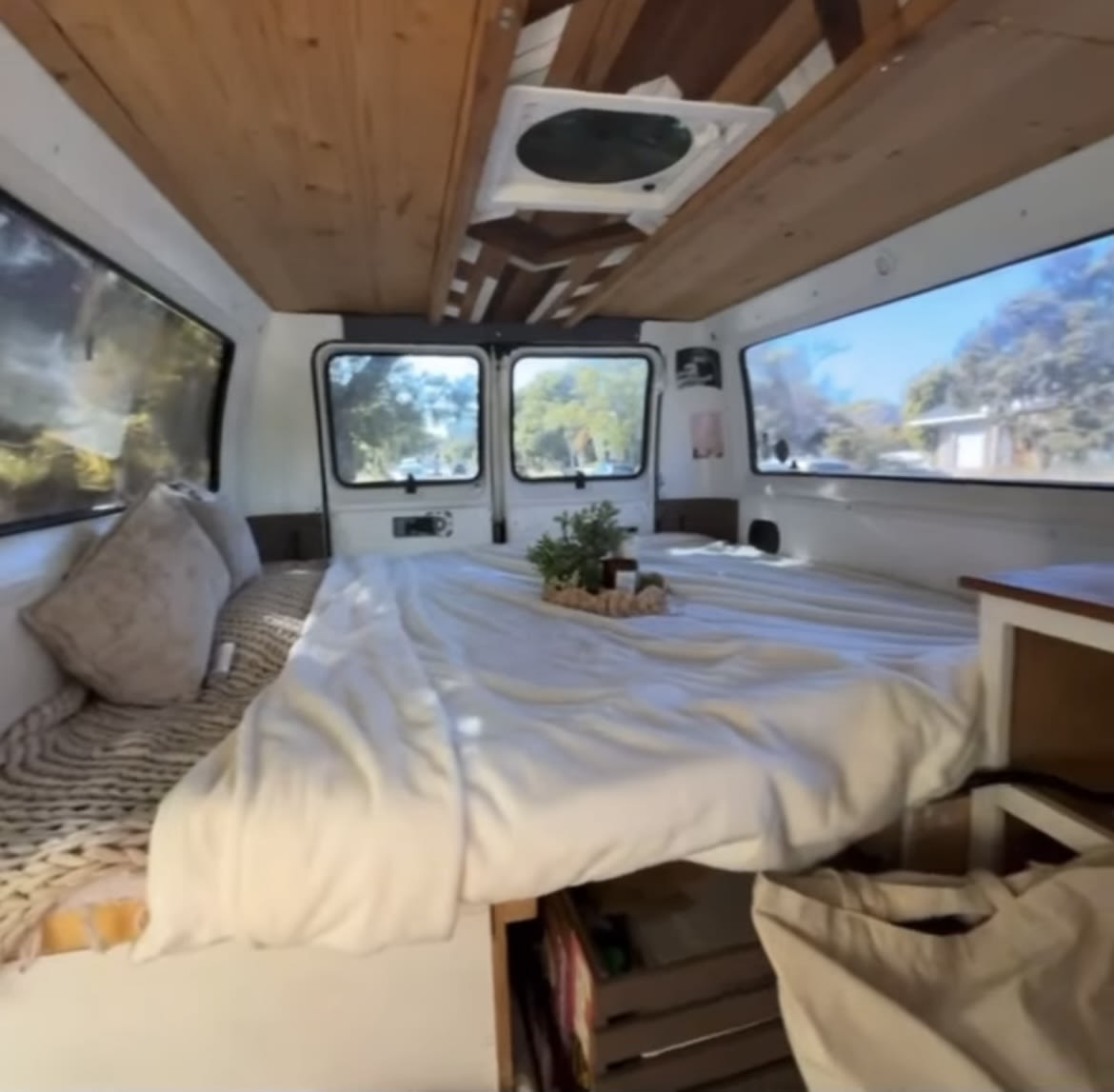 Cozy rv rental interior: A bright camper van features a comfy bed with wood ceilings & views. Perfect for van life adventures.. dodge dodge ram van 2001