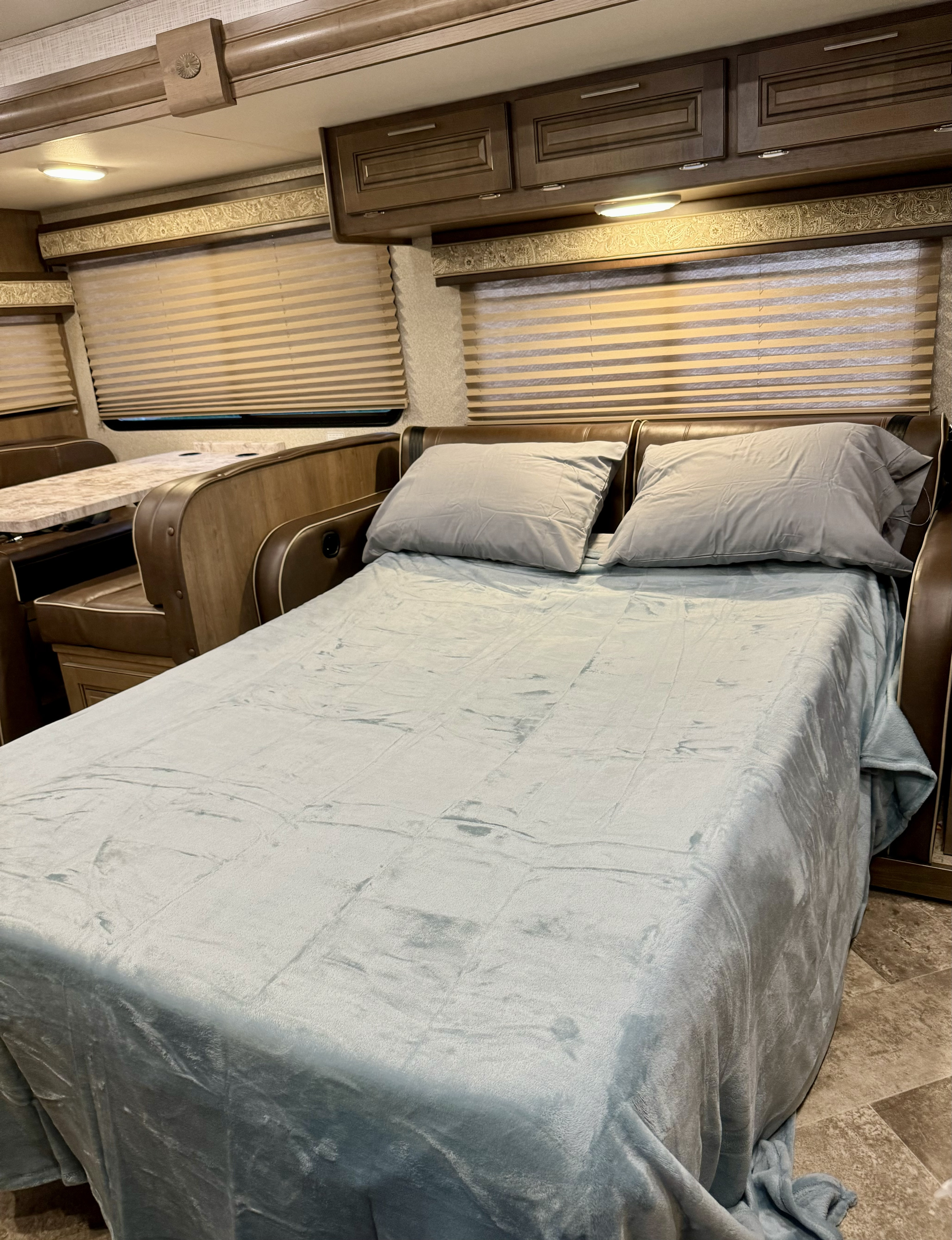 Cozy rv rental interior: A converted dinette bed with a soft blue blanket and pillows provides a comfortable sleeping space.. Georgetown GT3 2019