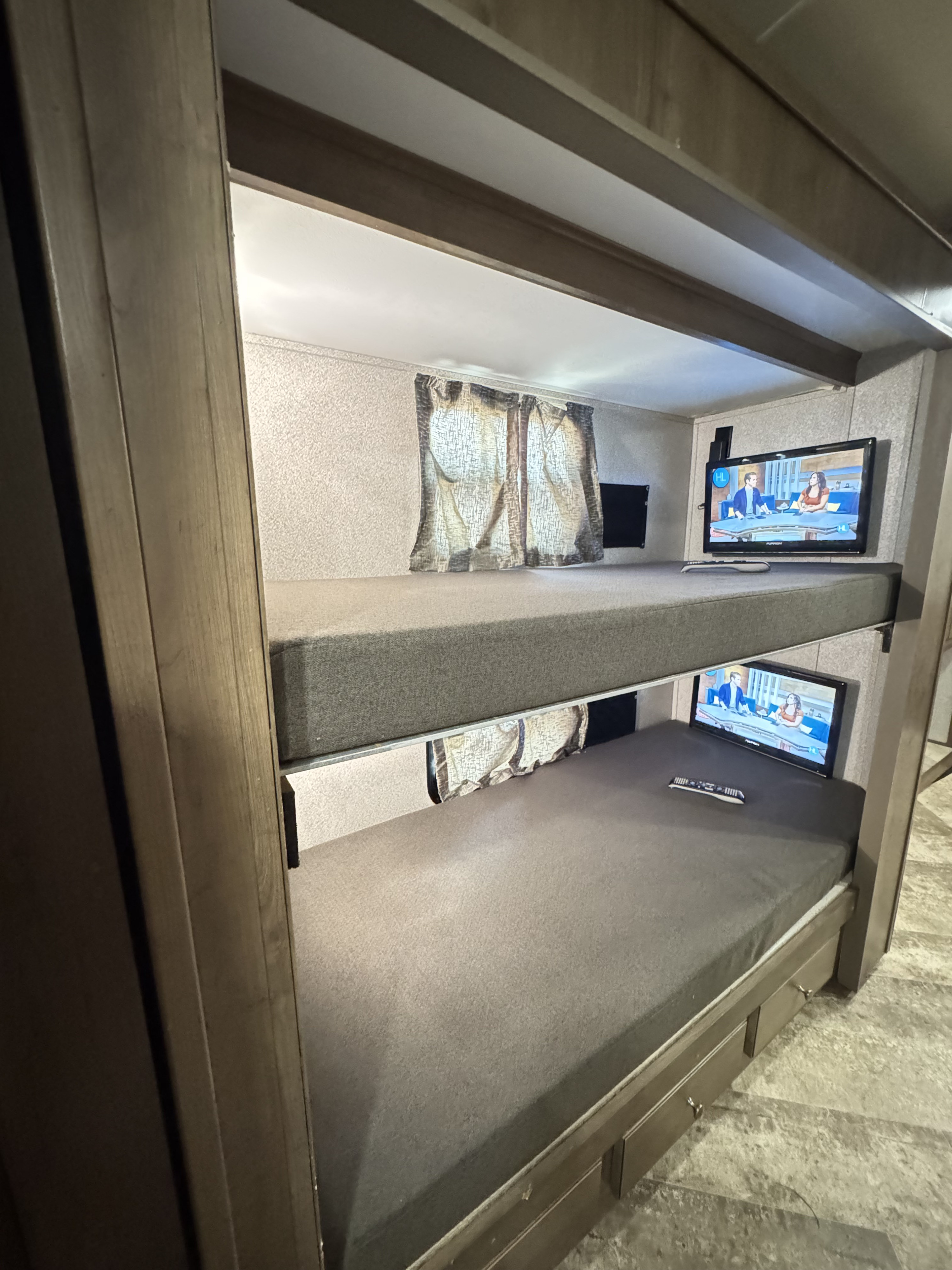 Cozy rv rental bunk beds with personal TVs, ideal for travelers. Each bunk features a screen and mattress in this compact camper layout.. Forest River Georgetown 2019