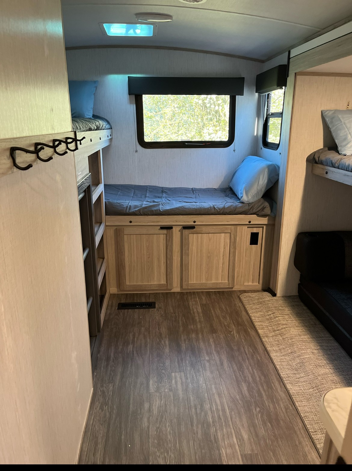 This cozy RV rental interior features light wood bunk beds, under-bed storage cabinets, and natural light from outside windows.. Cruiser RV Shadow Cruiser 2022