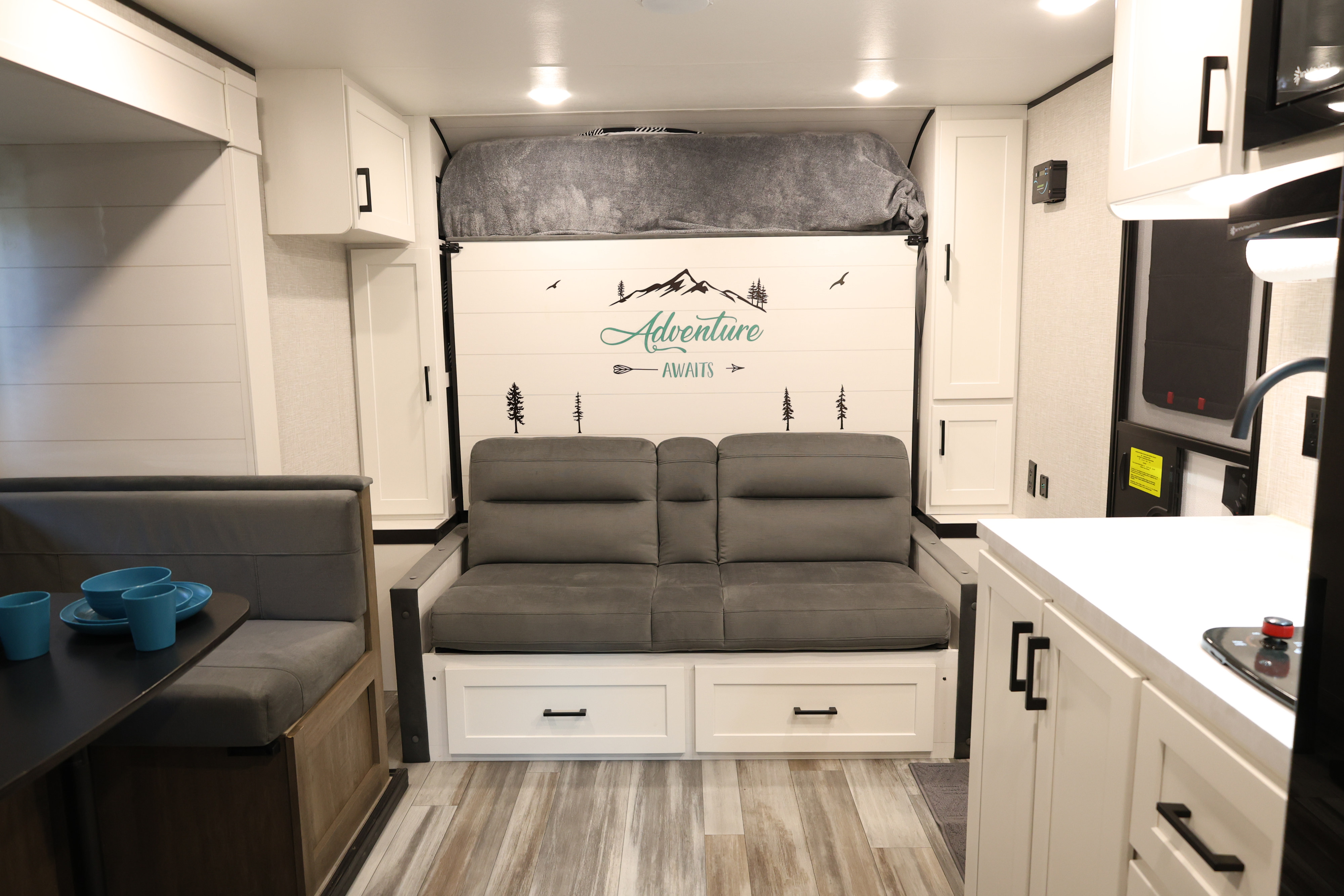 Bright rv rental interior featuring a convertible sofa bed, dinette, and compact modern kitchen. Ideal for travel adventures.. Jayco Jay Flight SLX 2025