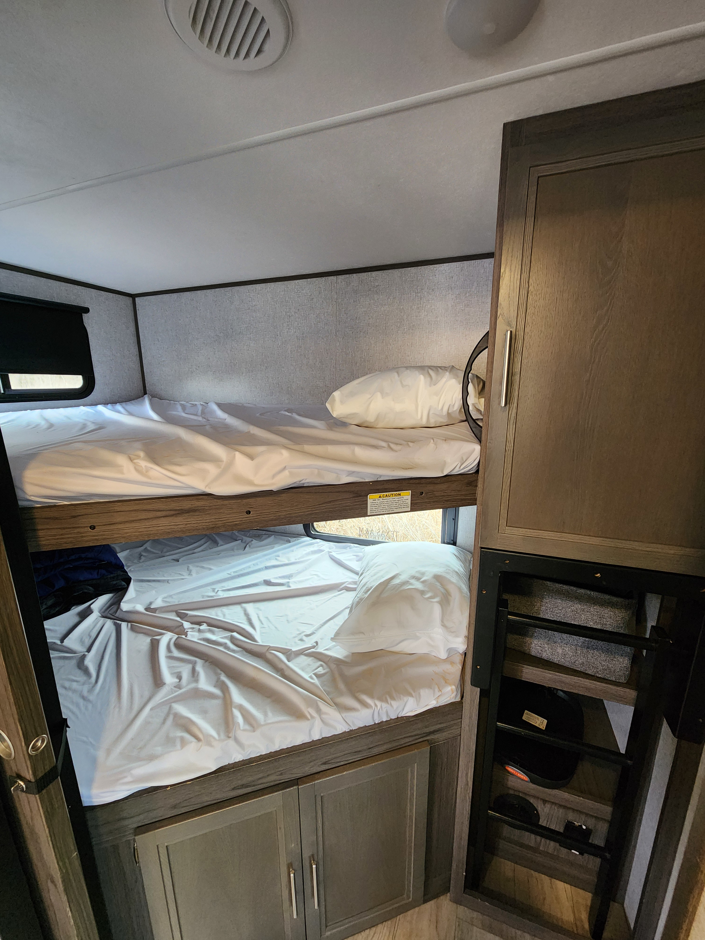 RV rental interior features comfortable bunk beds with white linens, window views, and integrated storage for your adventure.. Dutchmen Kodiak Ultra Lite 2021