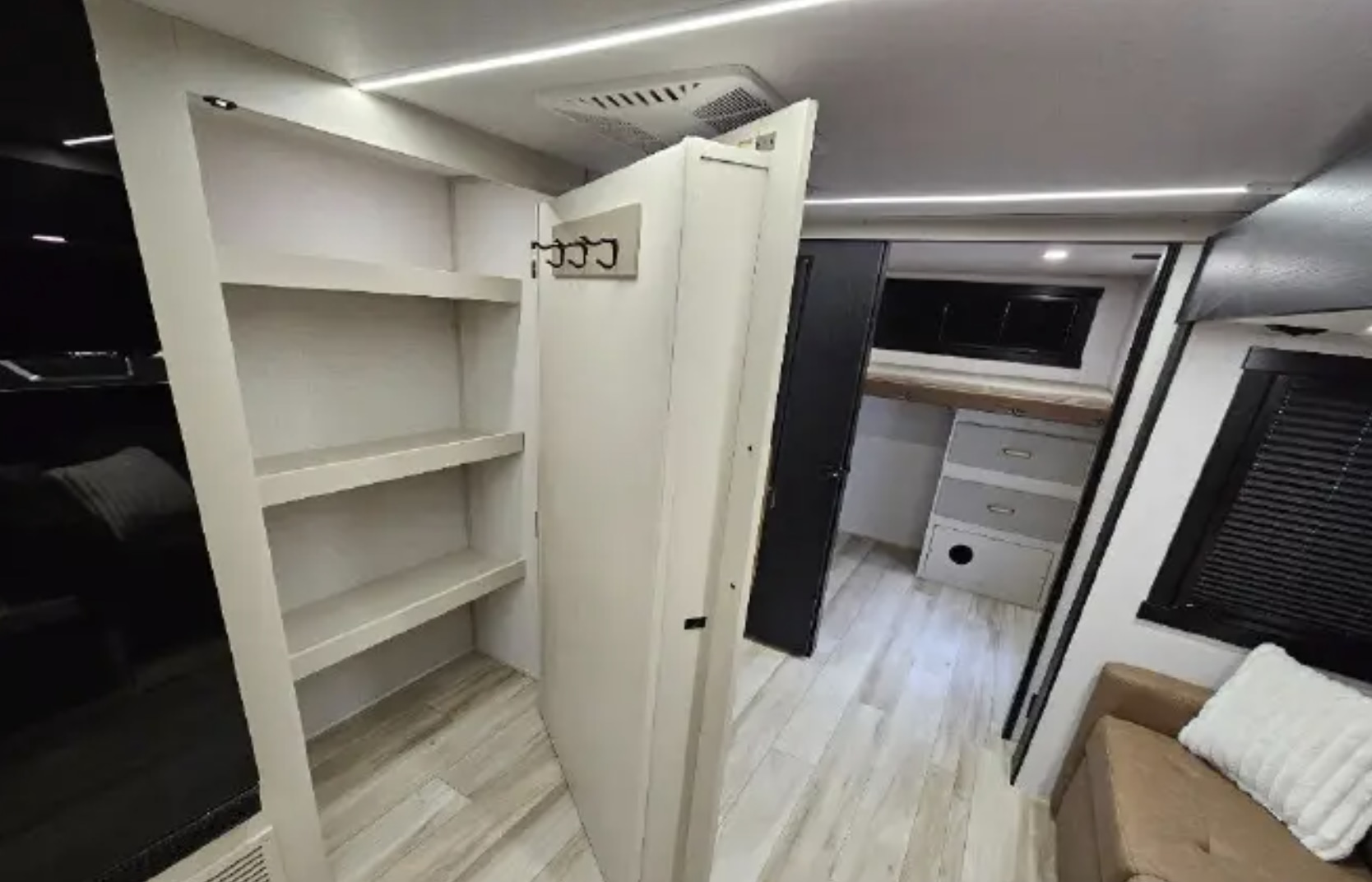 This RV rental interior features practical storage shelves, a coat rack, and a glimpse of the bedroom with bunk beds.. Forest River Wildwood Heritage Glen HL 2025