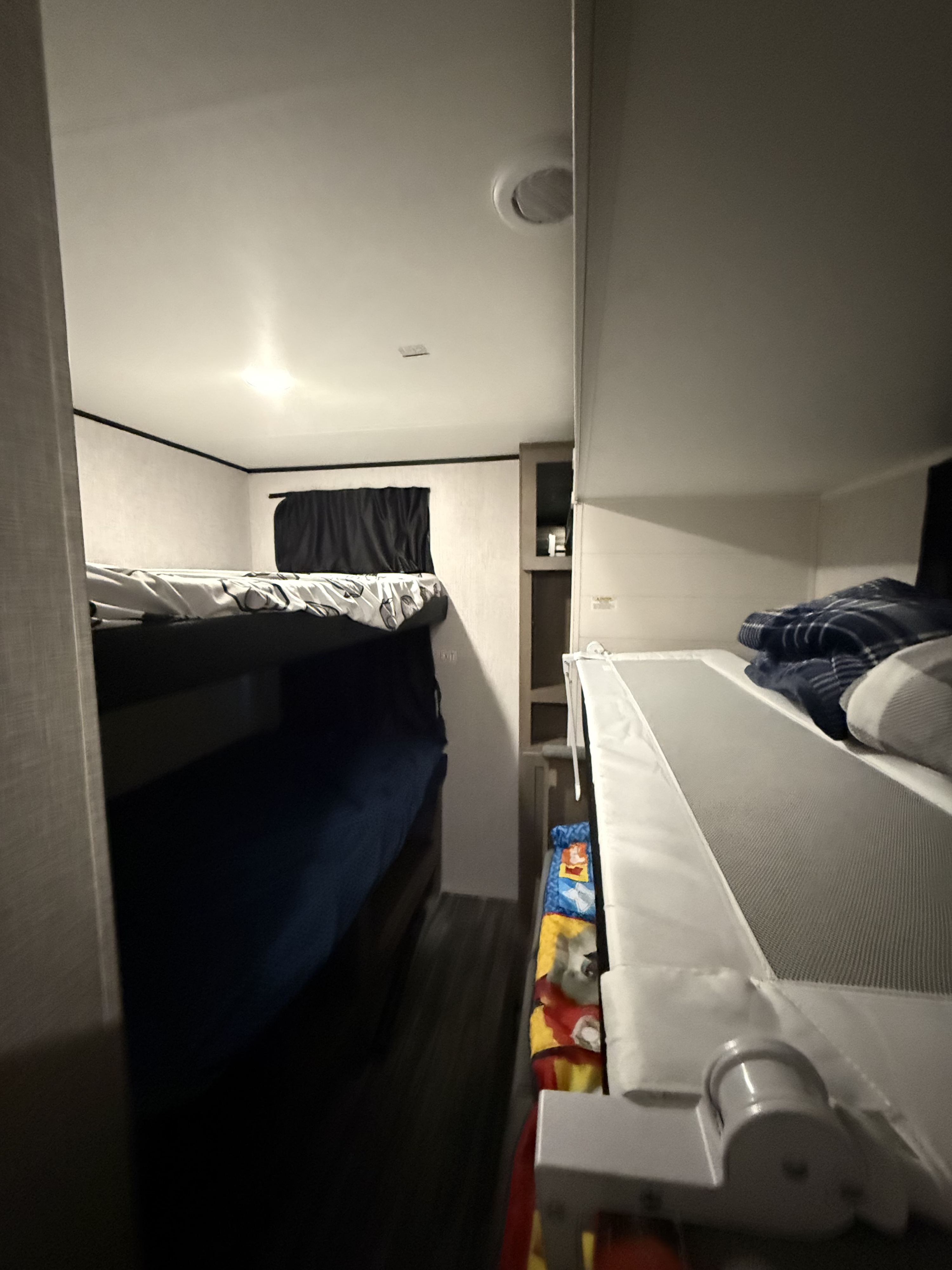 Inside an rv rental: compact bunk bed area with safety rail, window, and multiple sleeping spots for travel.. Jayco Jay Flight SLX 2025