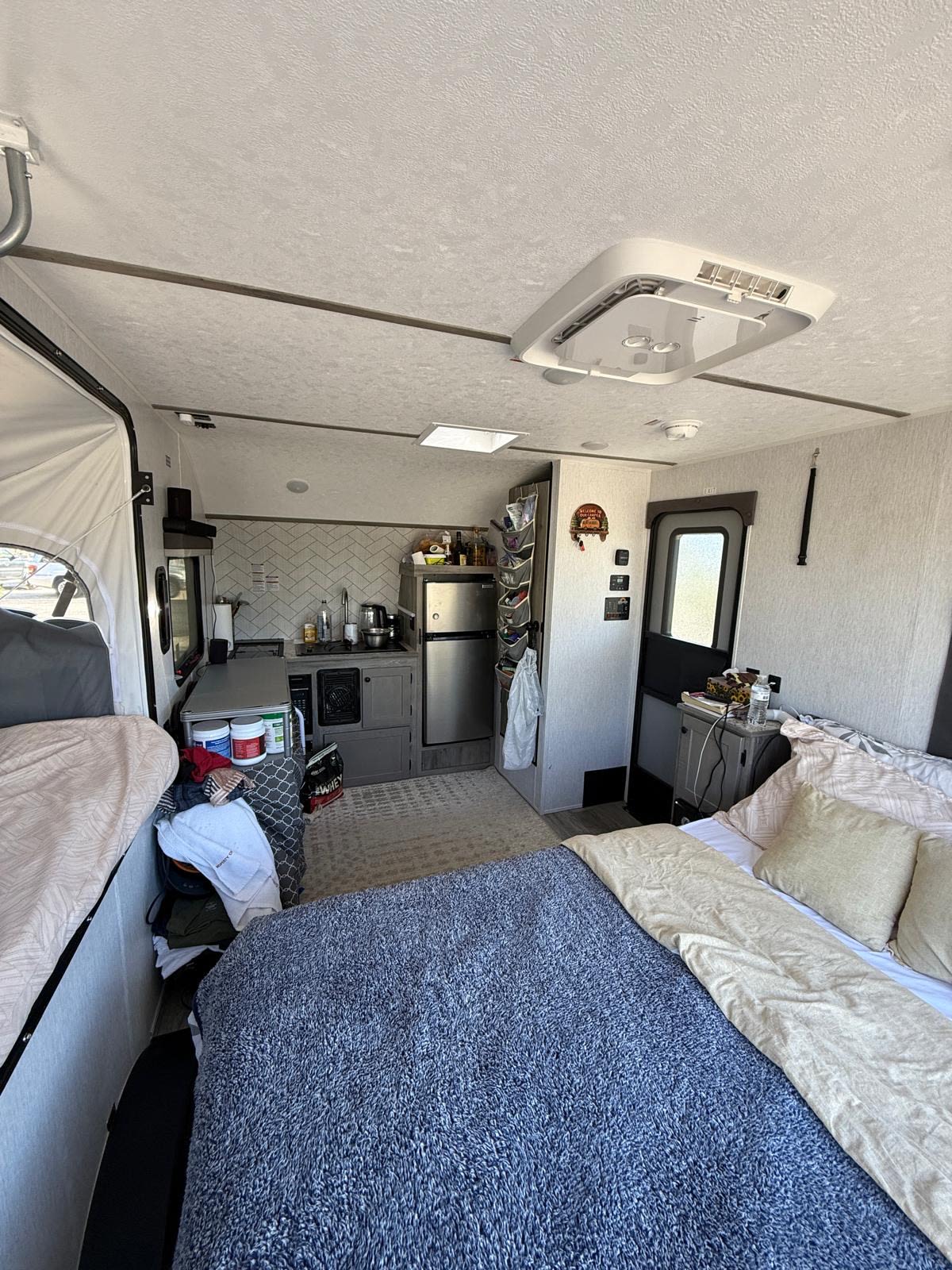 Bright RV rental interior featuring multiple beds, a compact kitchen, and general living area for comfortable travel.. Sun Lite 14 THX 2026