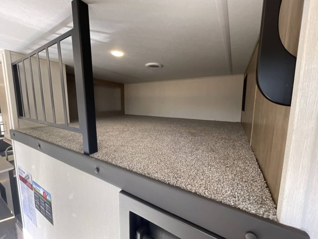 Experience this inviting RV rental loft: a carpeted bunk with a sturdy safety railing, providing extra sleeping space.. FOREST RIVER Campsite Elite 36RF 2026