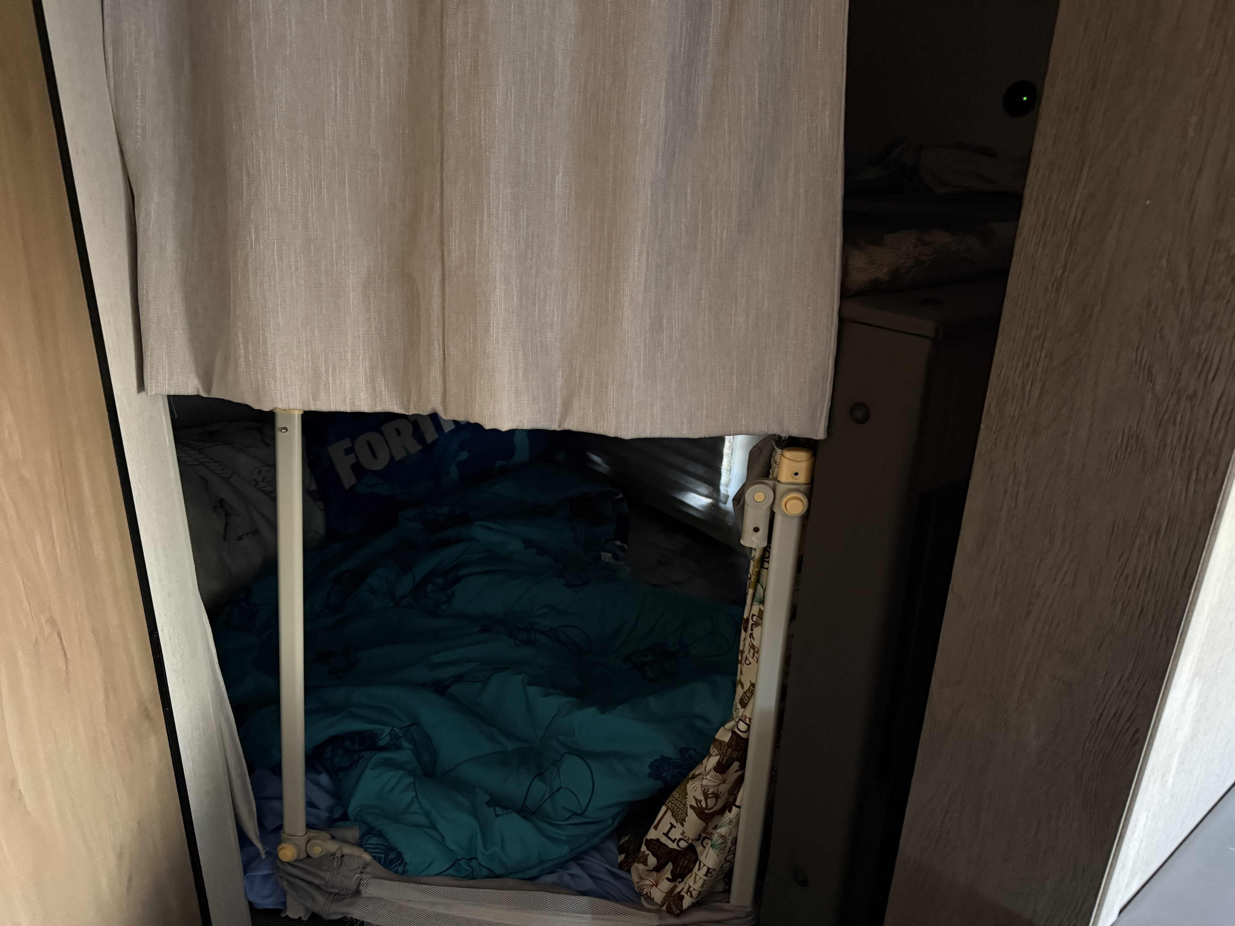 Cozy bunk bed with Fortnite bedding in an rv rental, partially hidden by curtains, creating a private sleeping area.. Forest River Cherokee Grey Wolf 2024