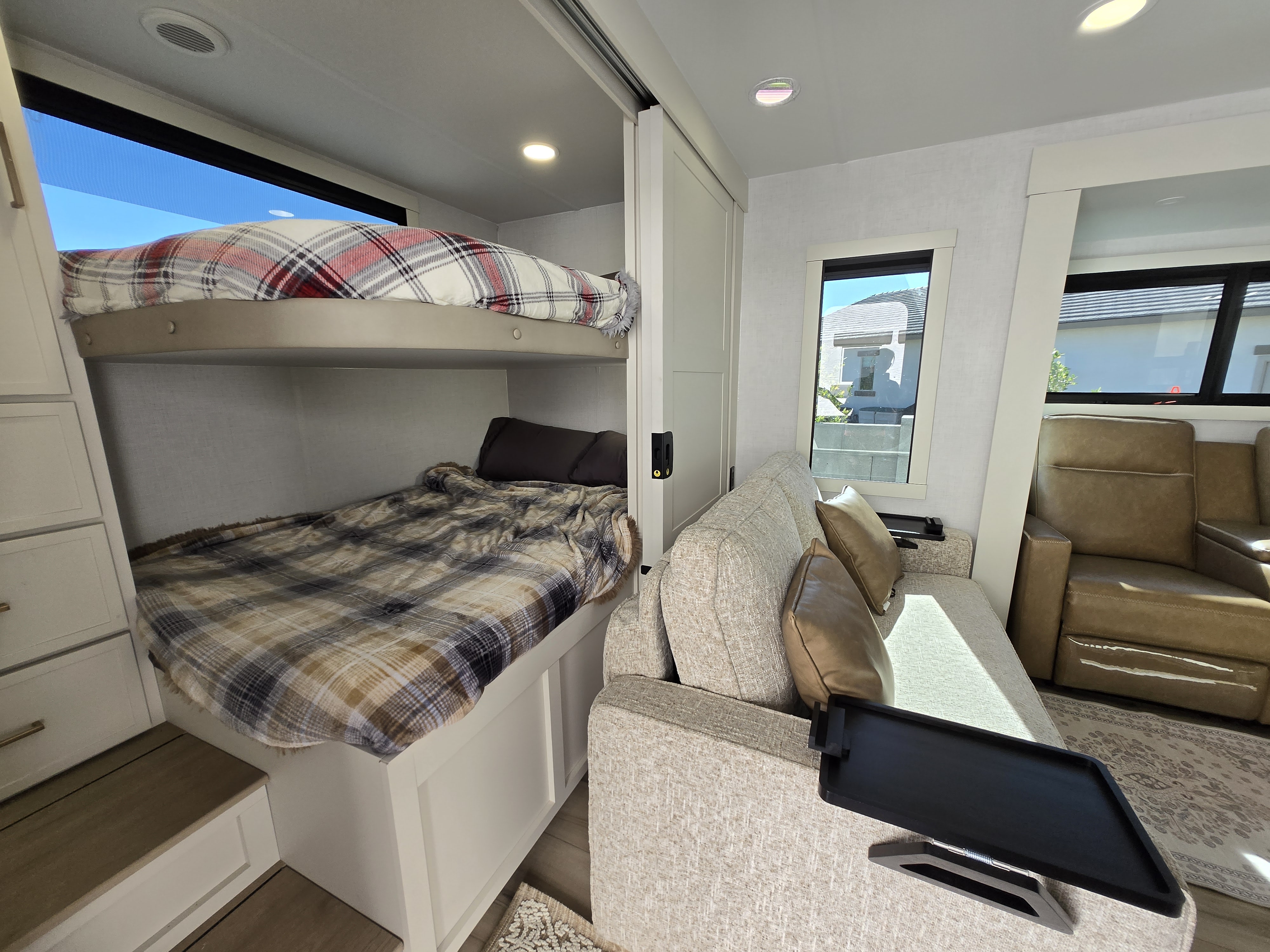 Cozy RV rental interior with bunk beds, a comfortable sofa, and bright windows, ideal for family travel.. Brinkley Model I 294 2026