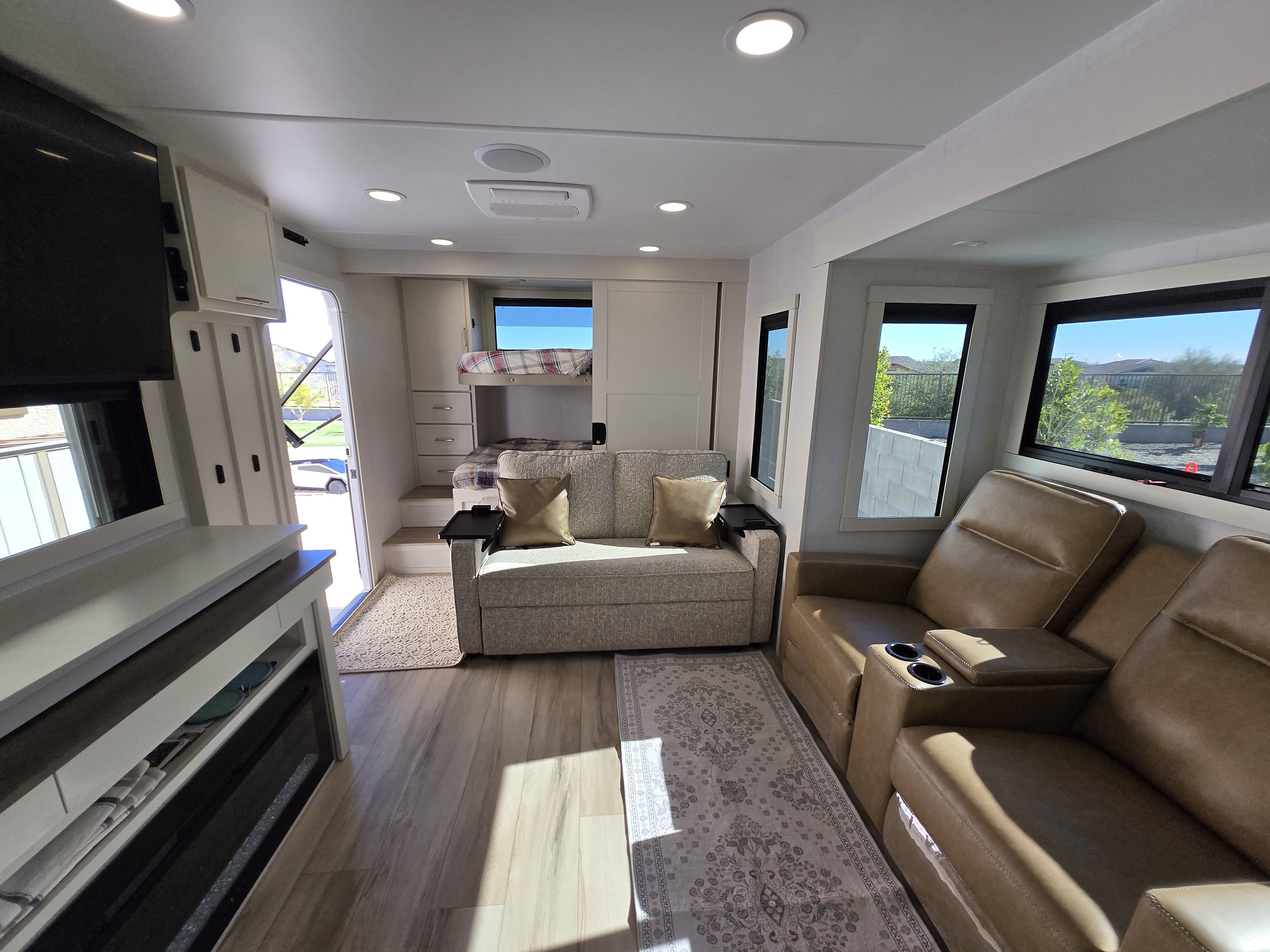 This bright RV rental interior offers recliners, a pull-out sofa, bunk beds, and a cozy living space with wood-look flooring.. Brinkley Model I 294 2026