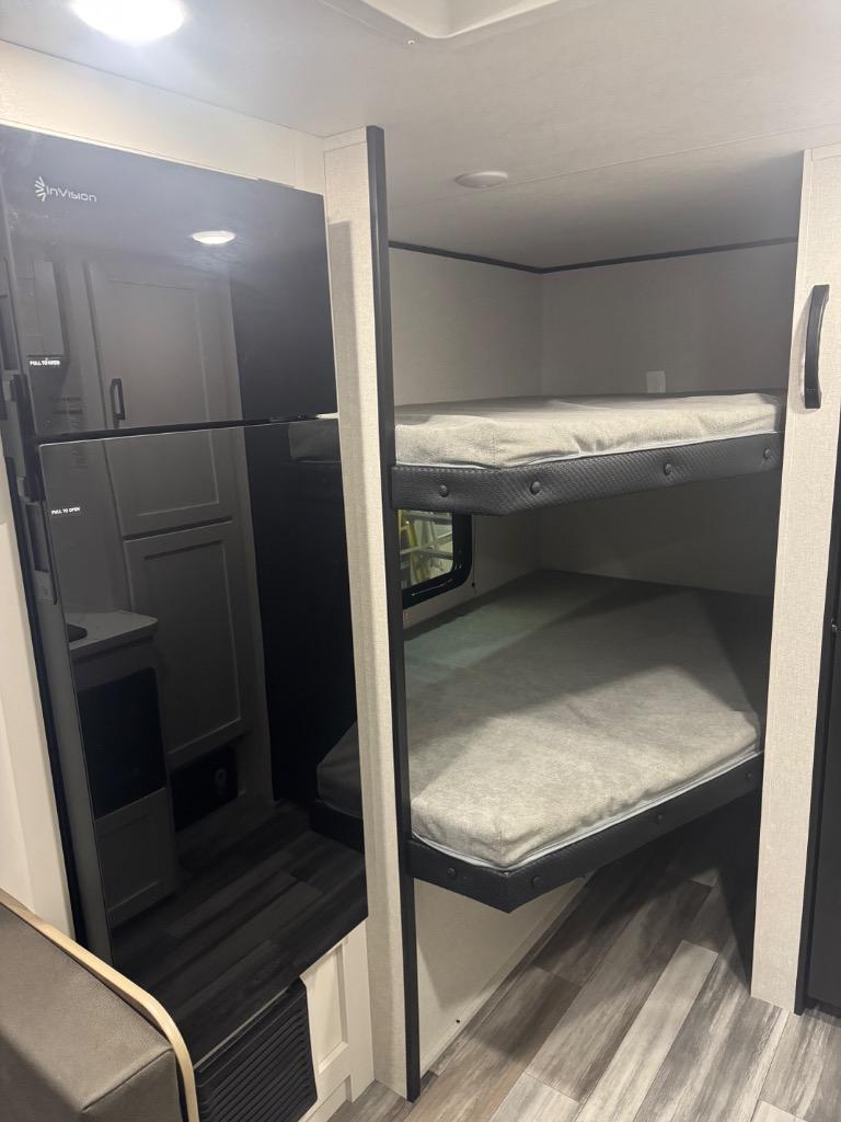 Spacious RV rental interior with modern InVision refrigerator and cozy bunk beds, ideal for family travel.. Jayco Jayflight SLX 250BH 2026