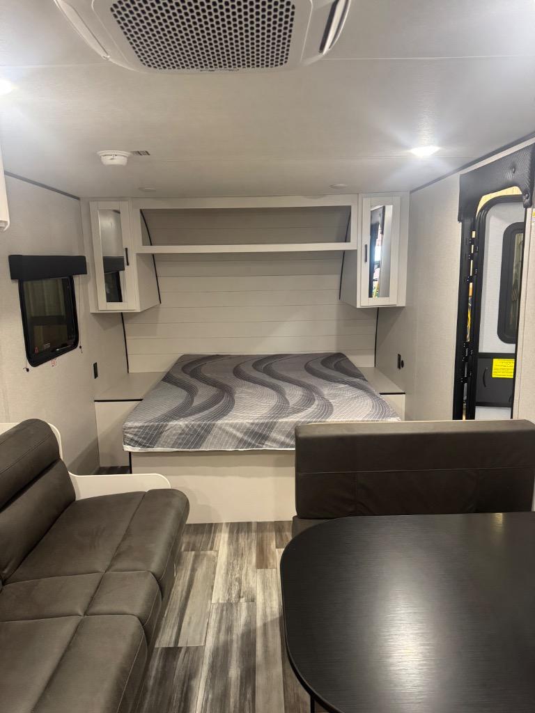 Cozy RV rental interior shows a bed with storage, sofa, and dinette. Ideal for comfortable camper travel.. Jayco Jayflight SLX 250BH 2026