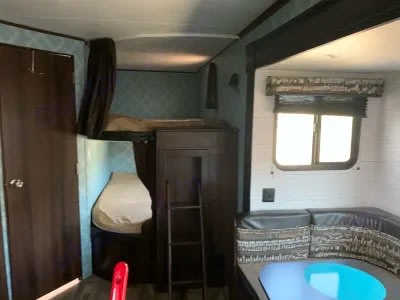 Cozy RV rental interior with bunk beds, a dinette, and a bright window, perfect for family travel.. Jayco Jay Flight SLX Baja Edition 2018