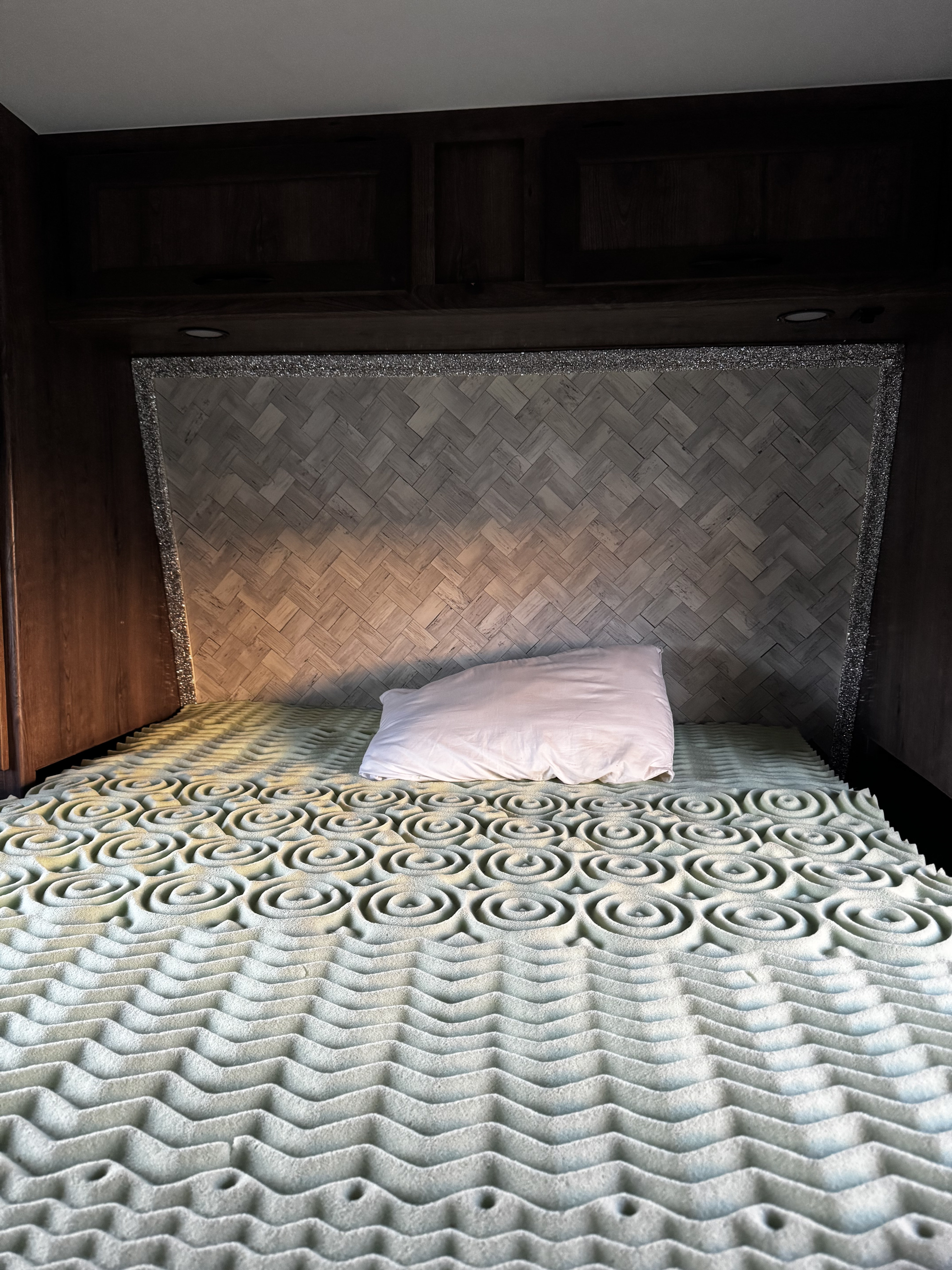 Cozy RV rental bed featuring a textured memory foam mattress topper, white pillow, and a glitter-trimmed headboard.. Eclipse Recreational Vehicles Attitude 2016