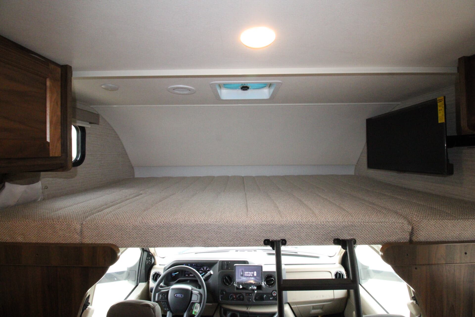 Spacious RV rental cab-over bunk bed with TV and cockpit view. Comfortable sleeping for your road trip adventure.. Winnebago Minnie Winnie 2022