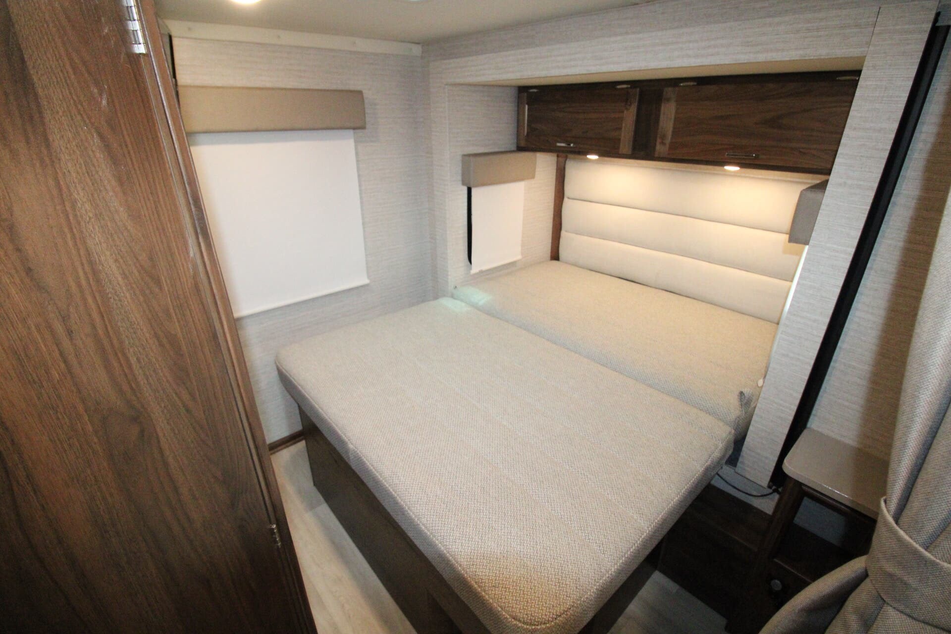 Modern RV rental interior: cozy bedroom with twin beds, overhead storage, and window blinds for comfortable sleeping.. Winnebago Minnie Winnie 2022