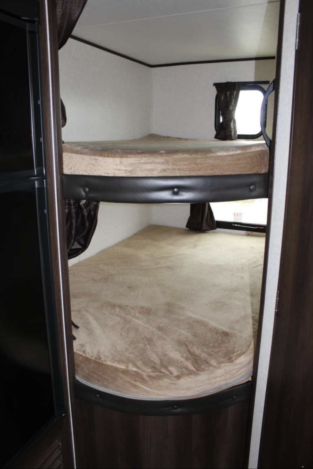 Cozy rv rental bunk beds with tan mattresses inside a compact RV, perfect for family travel or camping adventures.. Jayco Jay Flight SLX 2018