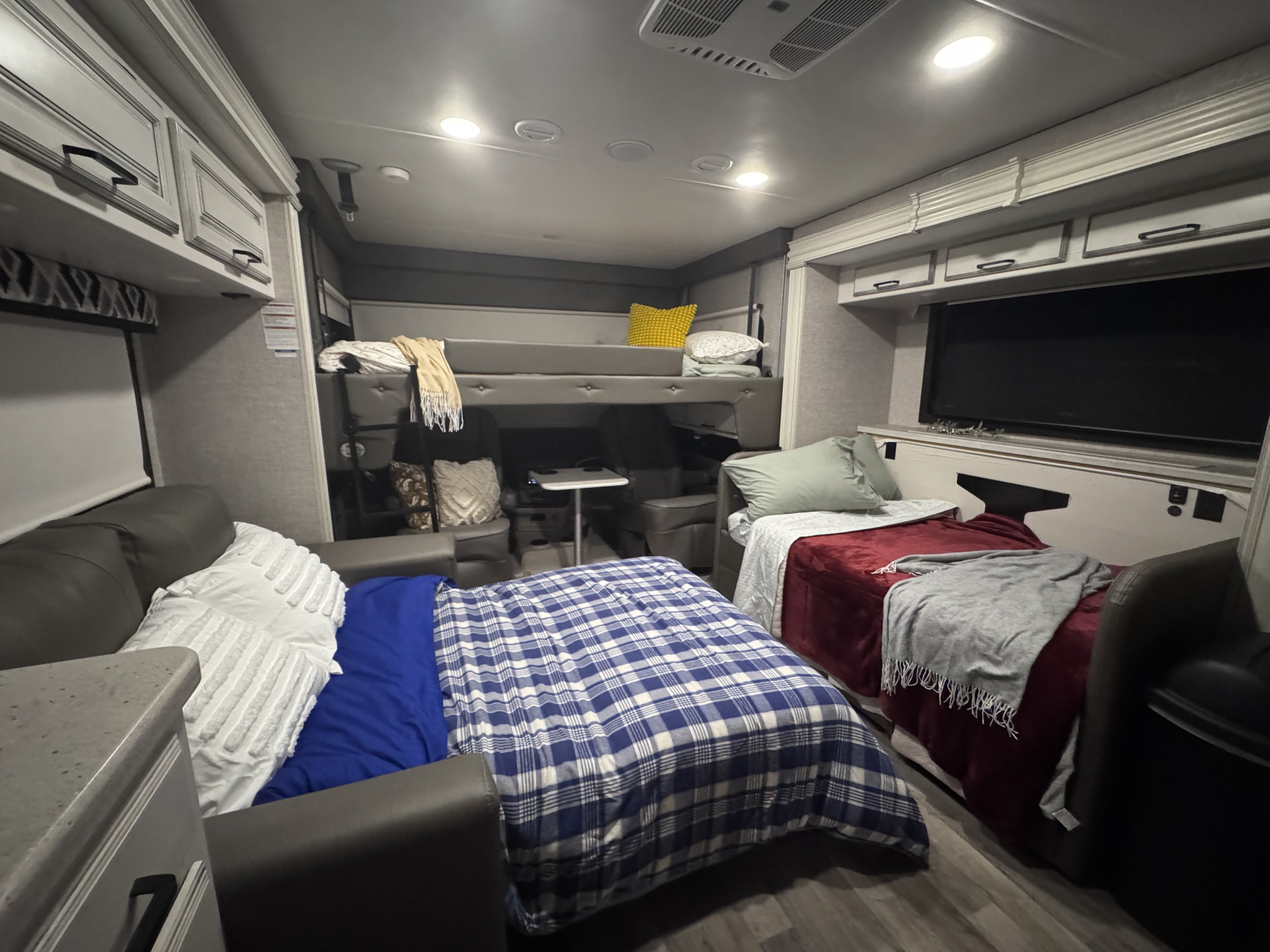 Cozy rv rental interior with bunk beds, multiple sleeping areas, and a TV for a comfortable mobile stay.. Jayco Precept 2022