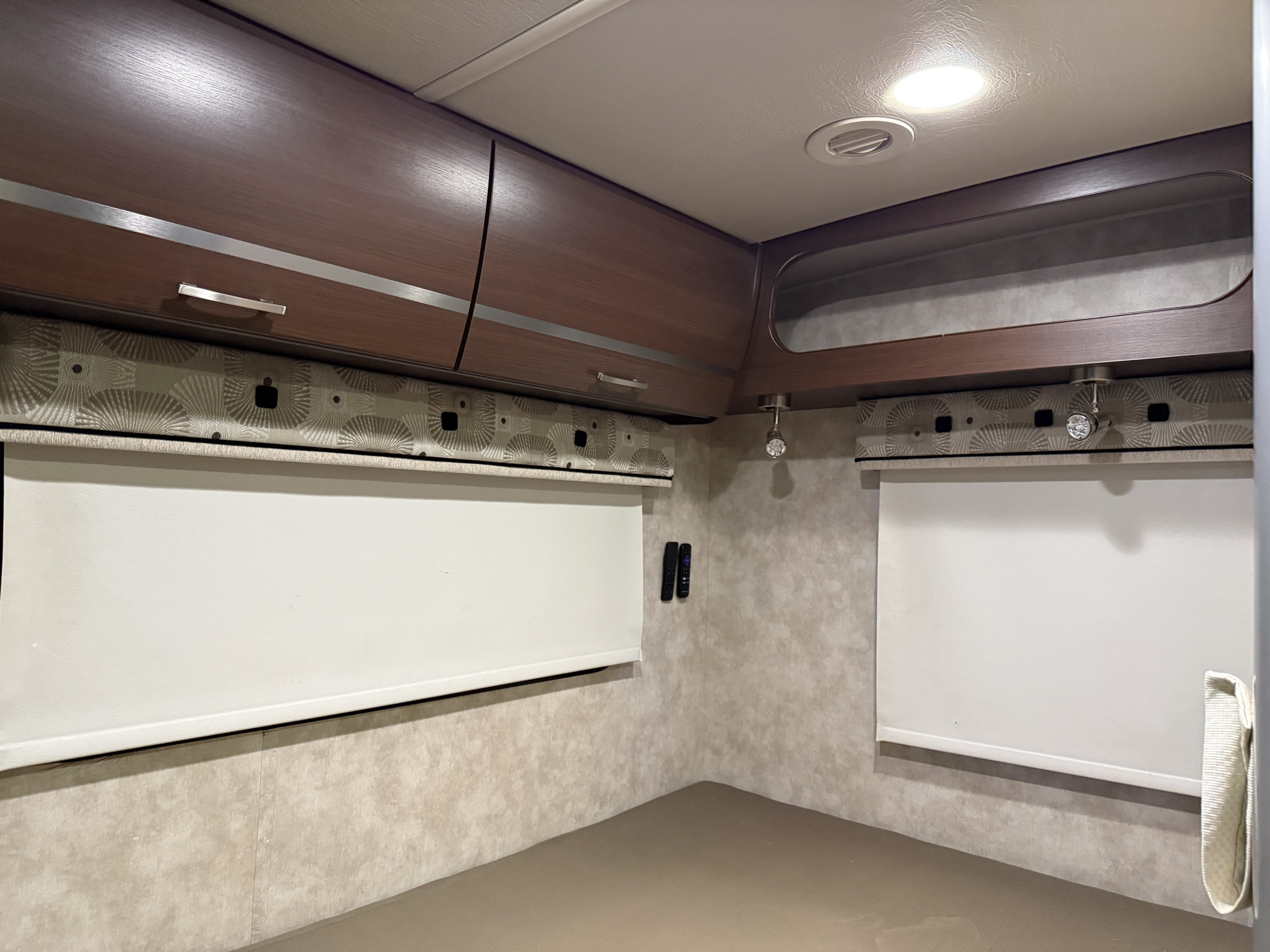 Cozy RV rental bedroom with wooden cabinets, roller blinds, and reading lights, perfect for a peaceful night.. Winnebago View 2014