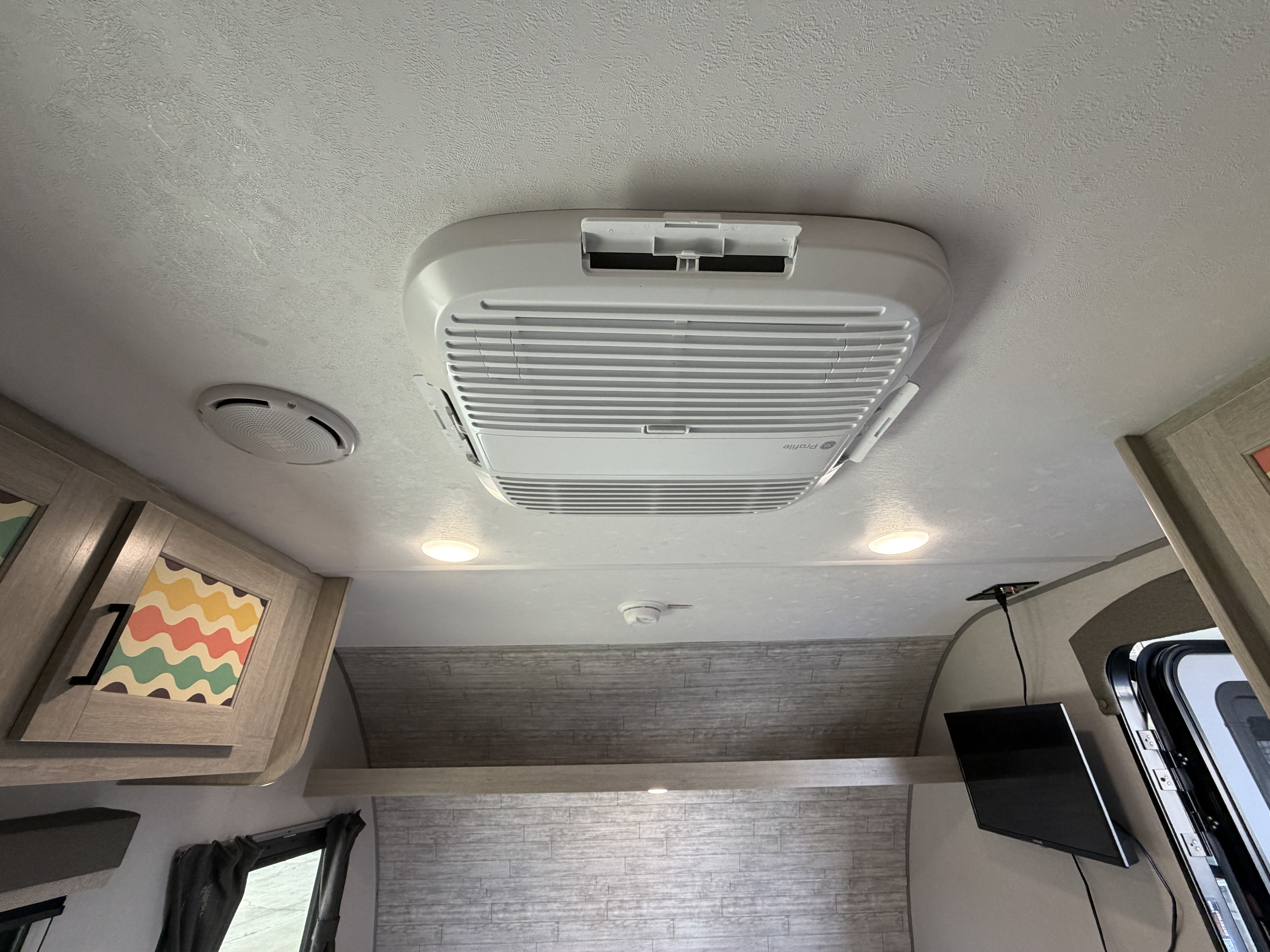 Interior of an rv rental, featuring the ceiling with a GE Profile AC unit, recessed lights, speaker, and smoke detector.. Forest River Aurora Aurora 2026