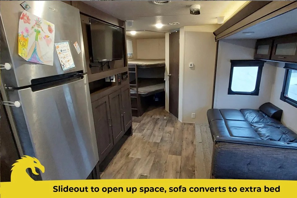Spacious RV rental interior with fridge, entertainment center, bunk beds, and a slide-out sofa that converts to a bed.. Forest River Salem 2018