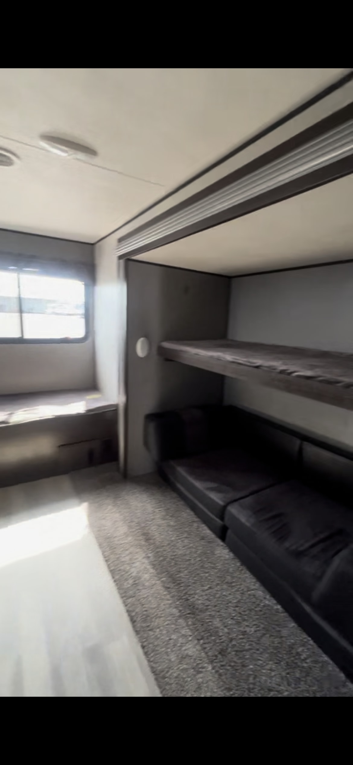 Spacious RV rental interior with bunk beds, a convertible sofa, and bright window, perfect for family adventures in a travel trailer.. Heartland RVs Prowler 2020