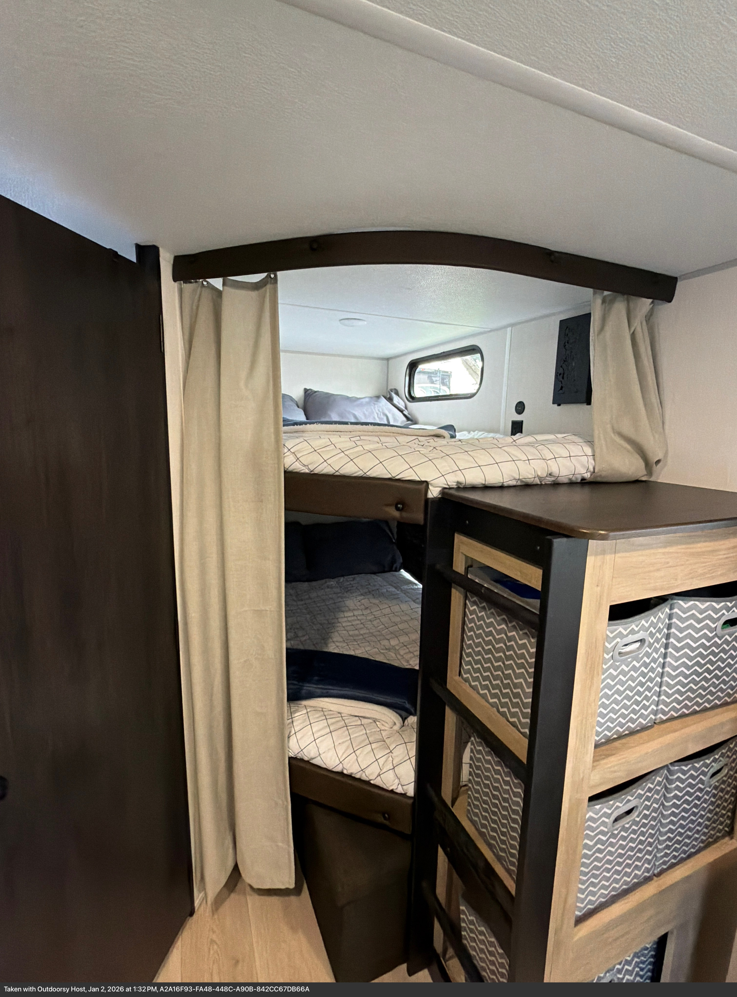 Cozy RV rental bunk beds feature privacy curtains, a window, and built-in storage cubbies with chevron bins.. Forest River Cherokee Grey Wolf 2026