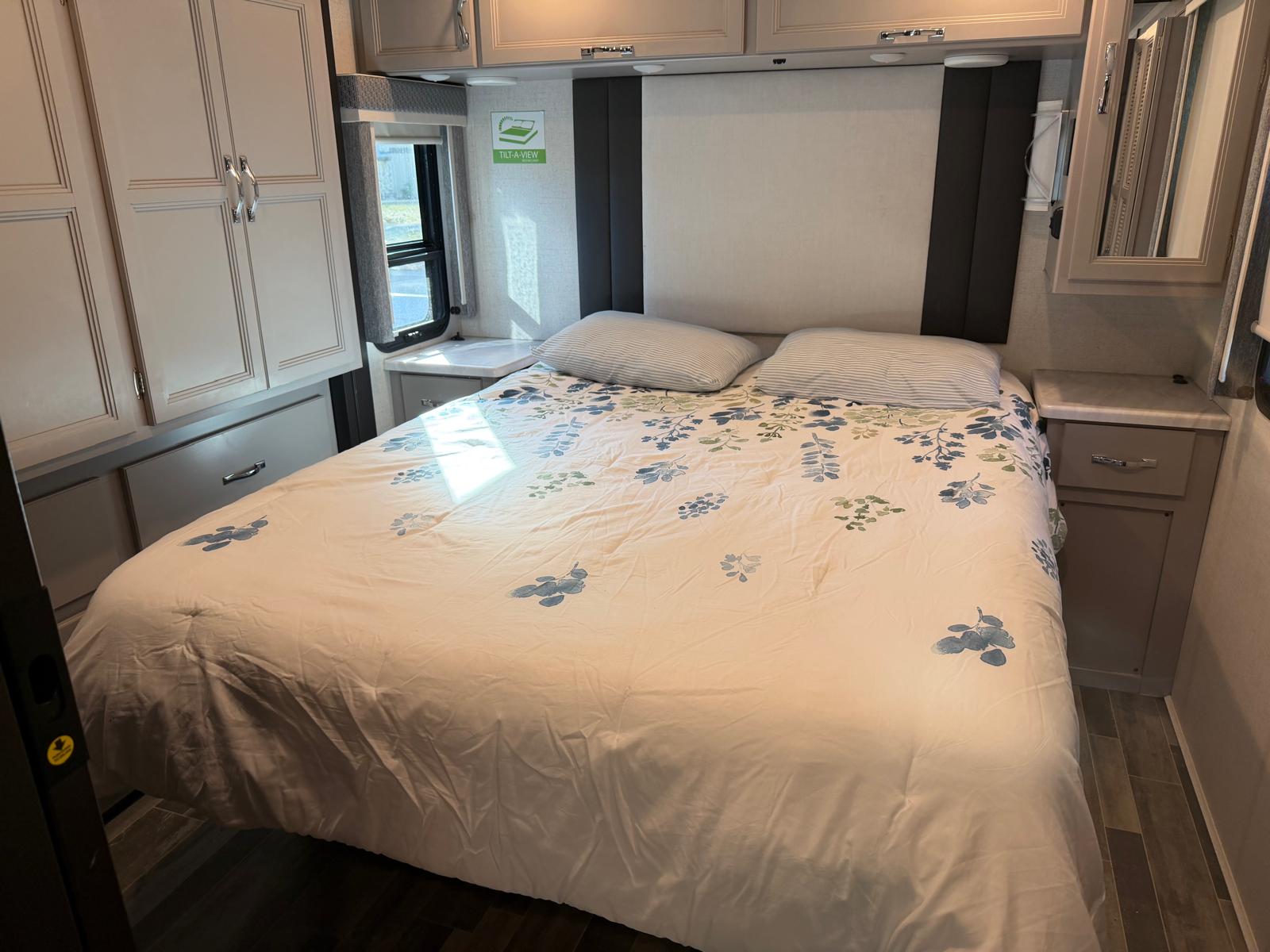 Explore this inviting RV rental bedroom. It offers a cozy queen bed, ample storage, and natural light for your trip.. Thor Palazzo 2024