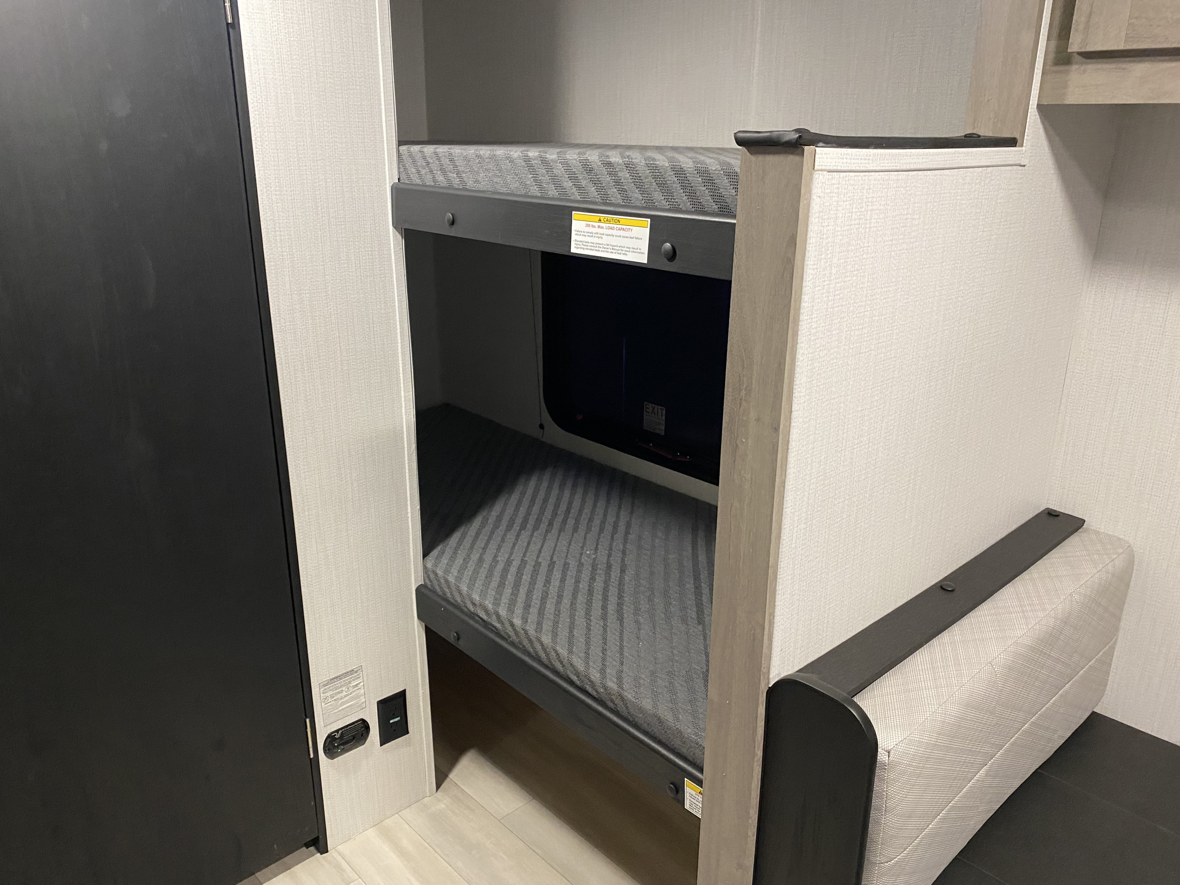 Comfortable RV rental bunk beds, rated for 200 lbs., with an electrical outlet and safety detector nearby.. Heartland RVs Prowler Lynx LE 2025