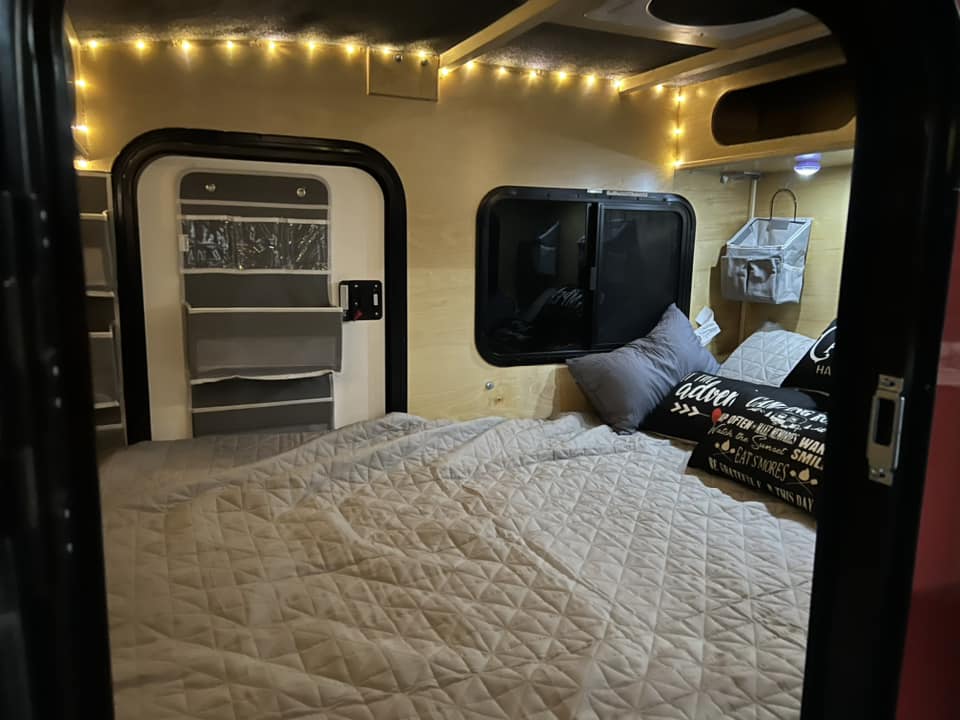 Cozy RV rental interior with a comfortable bed, string lights, and clever storage solutions for your next adventure.. Outbound Trailer Outbound Extreme 2026