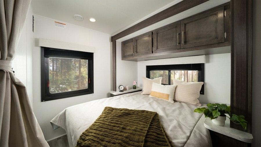 Cozy modern RV rental bedroom with forest views, a comfortable bed, and ample storage for a great trip.. Entegra Coach Odyssey SE 2025