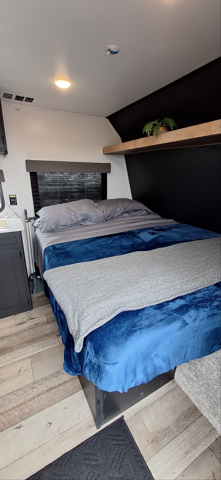 Cozy RV rental bedroom interior with a comfortable bed, window, and stylish shelf. Perfect for a relaxing travel stay.. Springdale 260BH 2022