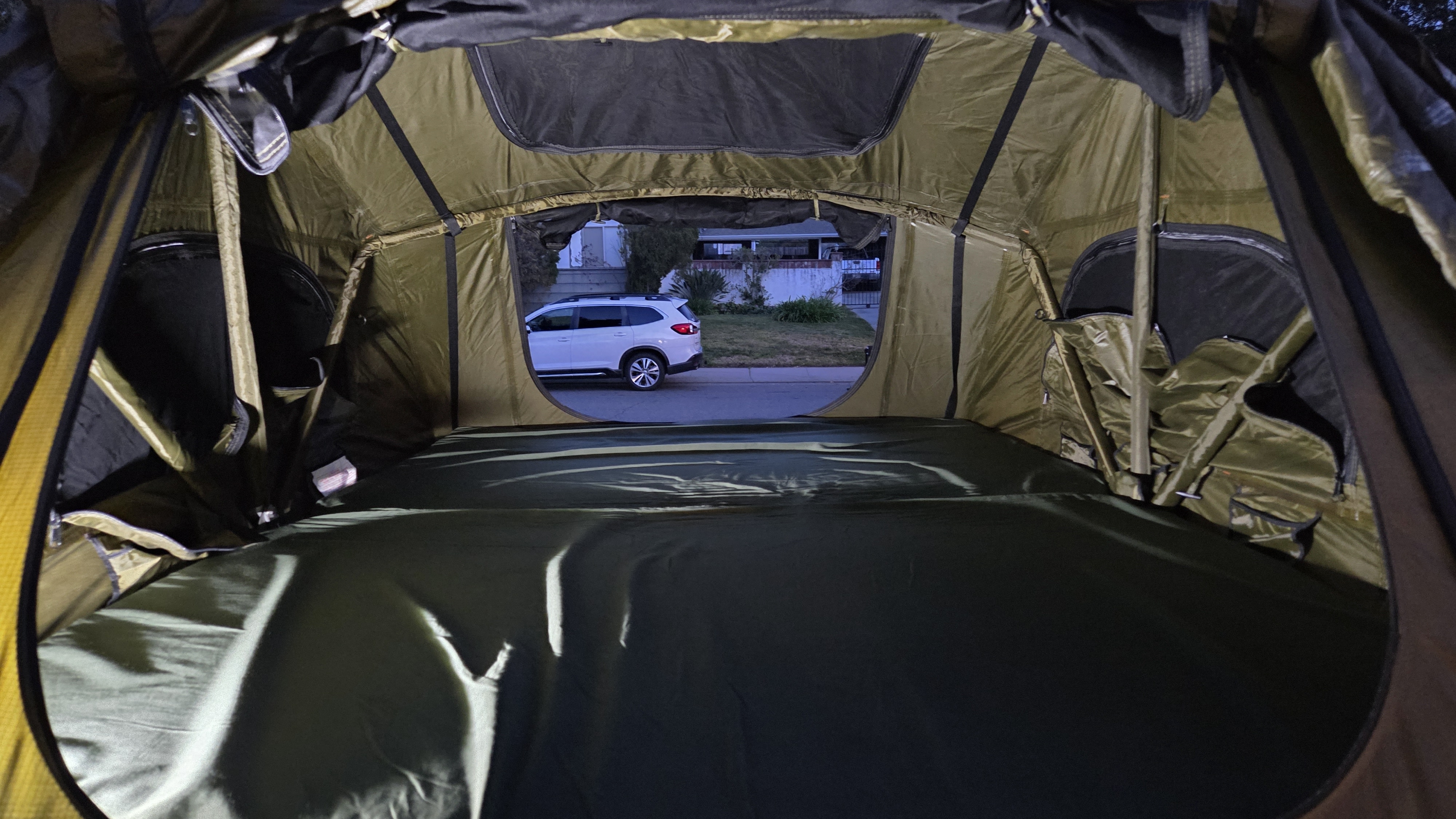 Cozy tent interior with mattress, looking out at an SUV. Ideal for your next rv rental adventure.. Oveerland vehicle Systems Off road Military Style Trailer with 23Zero Tent 2025