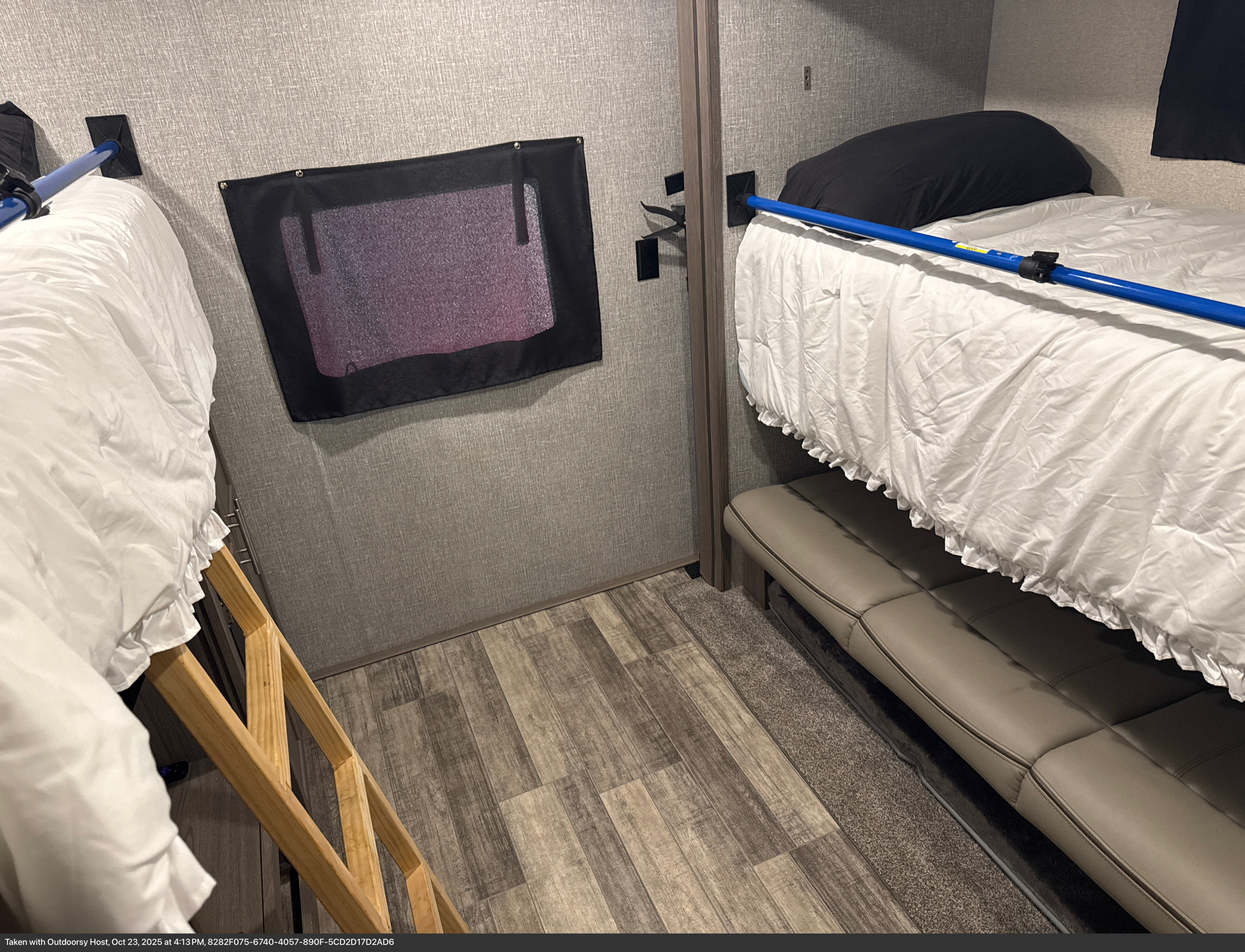 Cozy RV rental interior with bunk beds, including a lower sofa-bed, white bedding, and a safety net. Ideal for family trips.. Crossroads RV Volante 2021