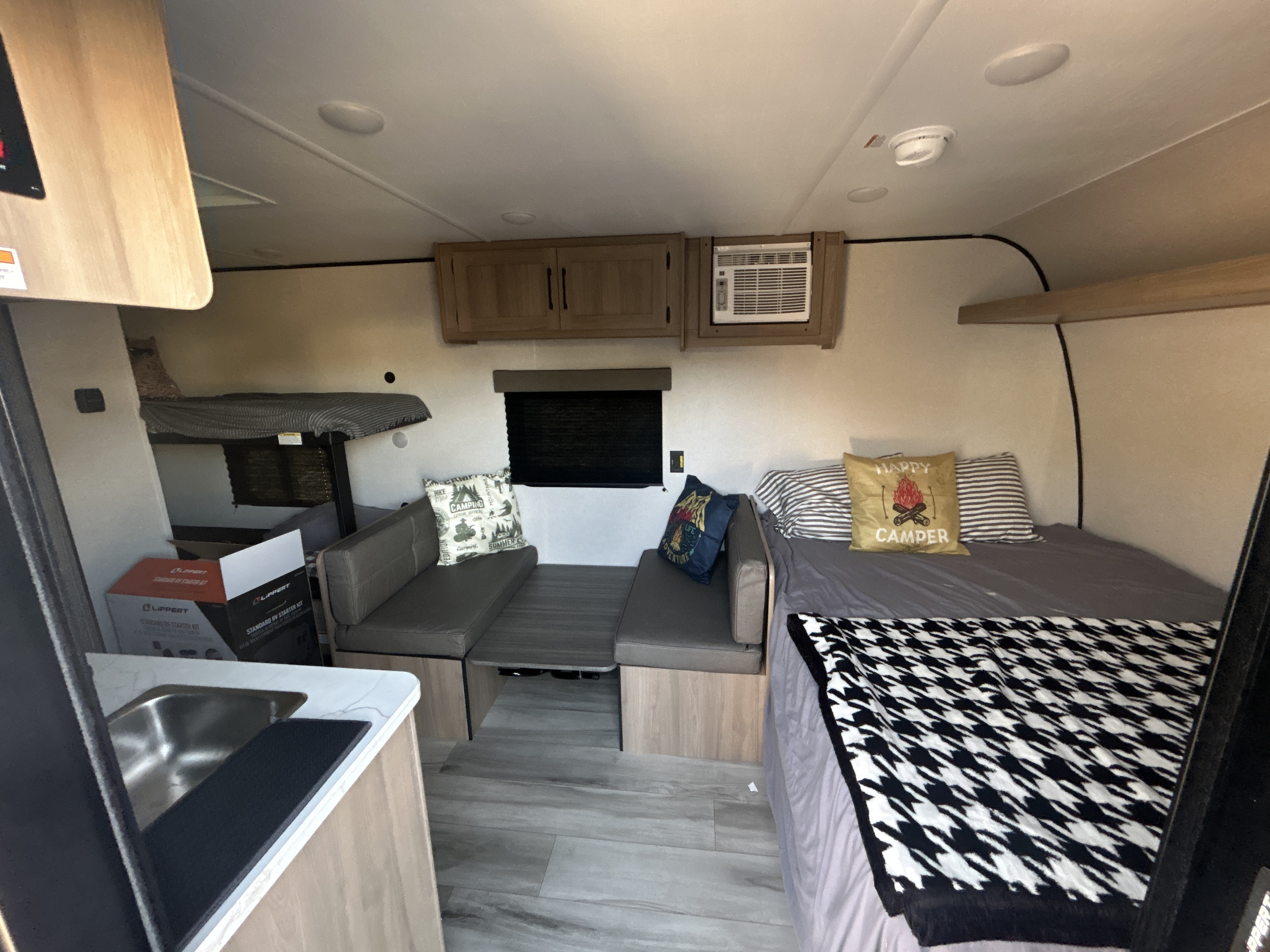 Compact rv rental interior featuring a dinette, bunk beds, and a comfortable main bed, perfect for your next adventure.. Dutchmen Coleman Lantern LT 2026