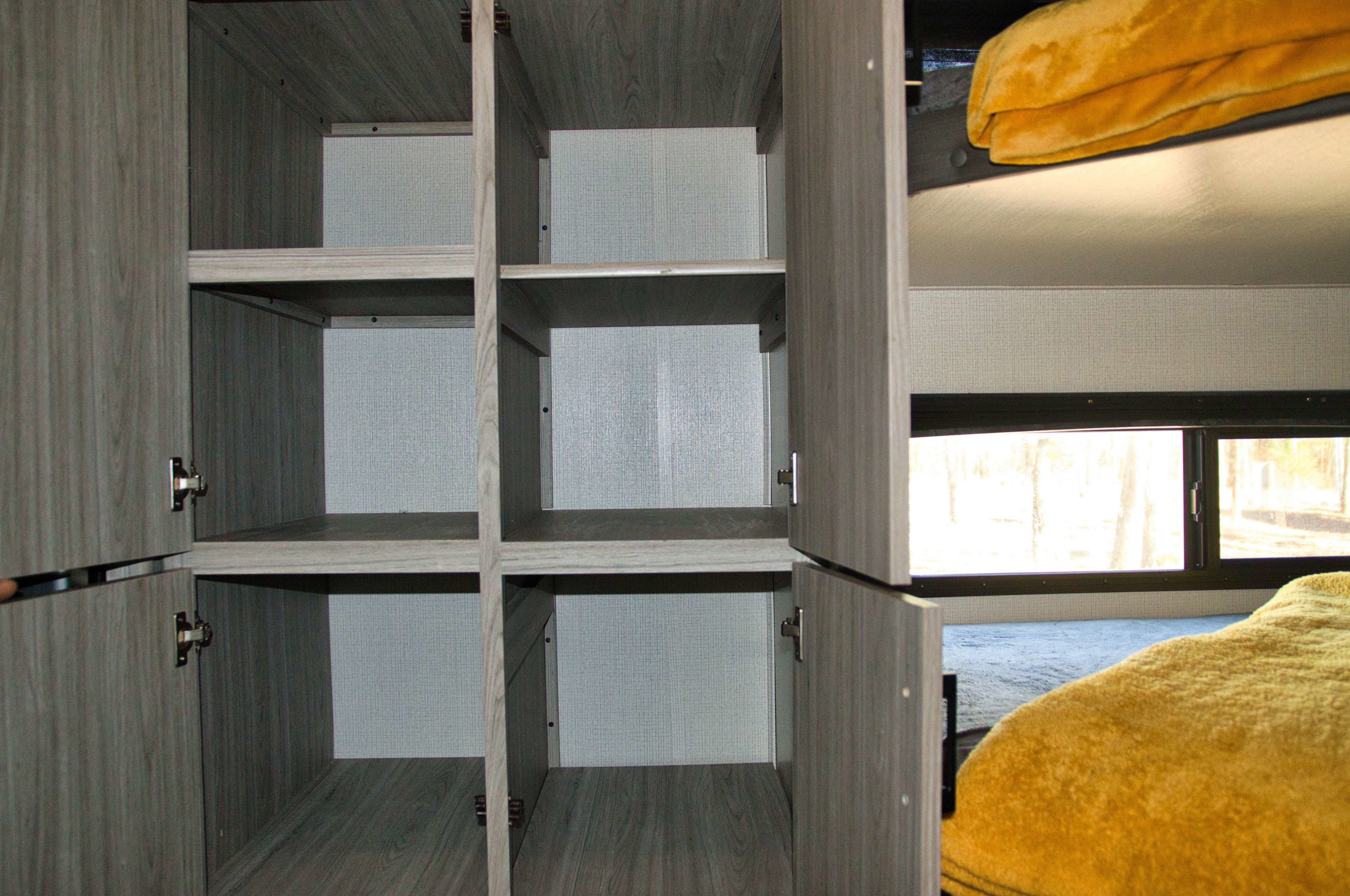 Spacious light wood-grain cabinets and cozy bunk beds are visible in this RV rental's interior.. Keystone RV Passport 2021