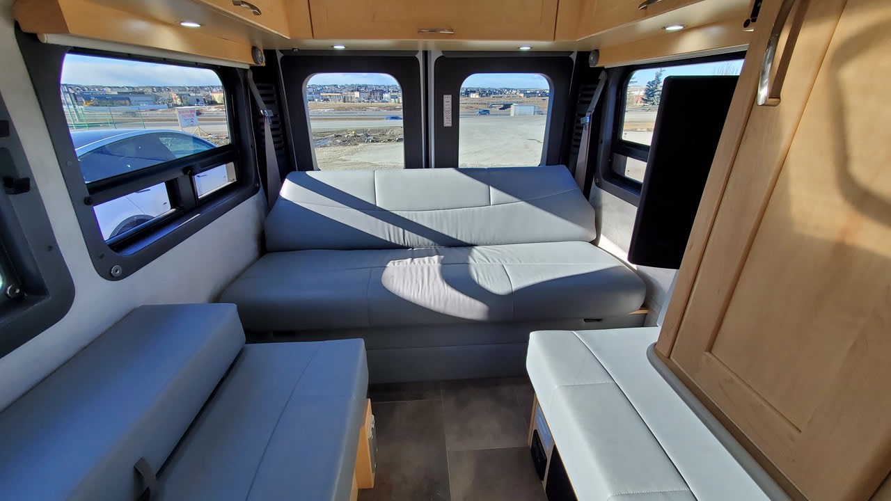 Bright RV rental interior with light gray seating and convertible sofa, perfect for comfortable travel and scenic views.. Pleasure-Way Pleasure-Way Class B 2018