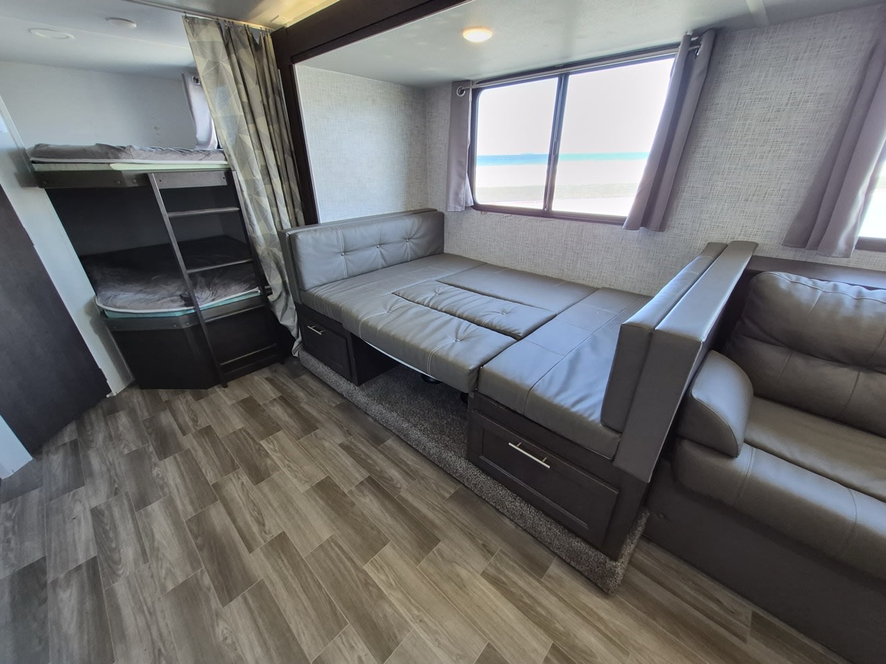 Cozy RV rental featuring bunk beds, a convertible dinette/sofa with storage, and scenic ocean views.. Forest River Salem Cruise Lite 2020