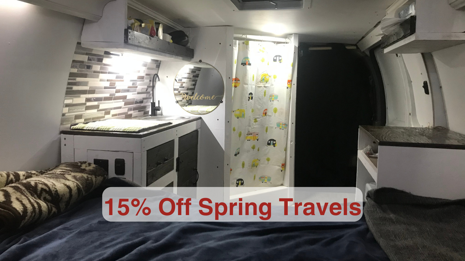 This cozy rv rental interior features a bed, kitchenette with sink, and shower area. A mirror reads 'welcome'. Get 15% off Spring Travels!. Chevrolet Express Extended 2007