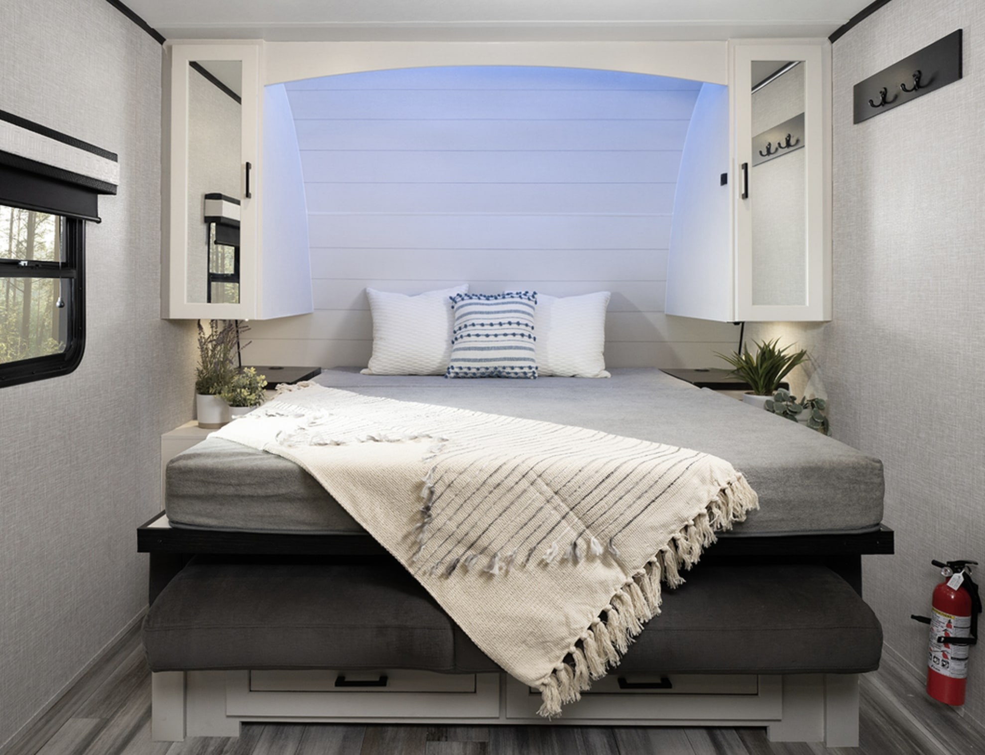 Cozy rv rental bedroom with a full-size bed, mirrored cabinets, under-bed storage, and blue ambient lighting.. Jayco JayFeather AIr 2025