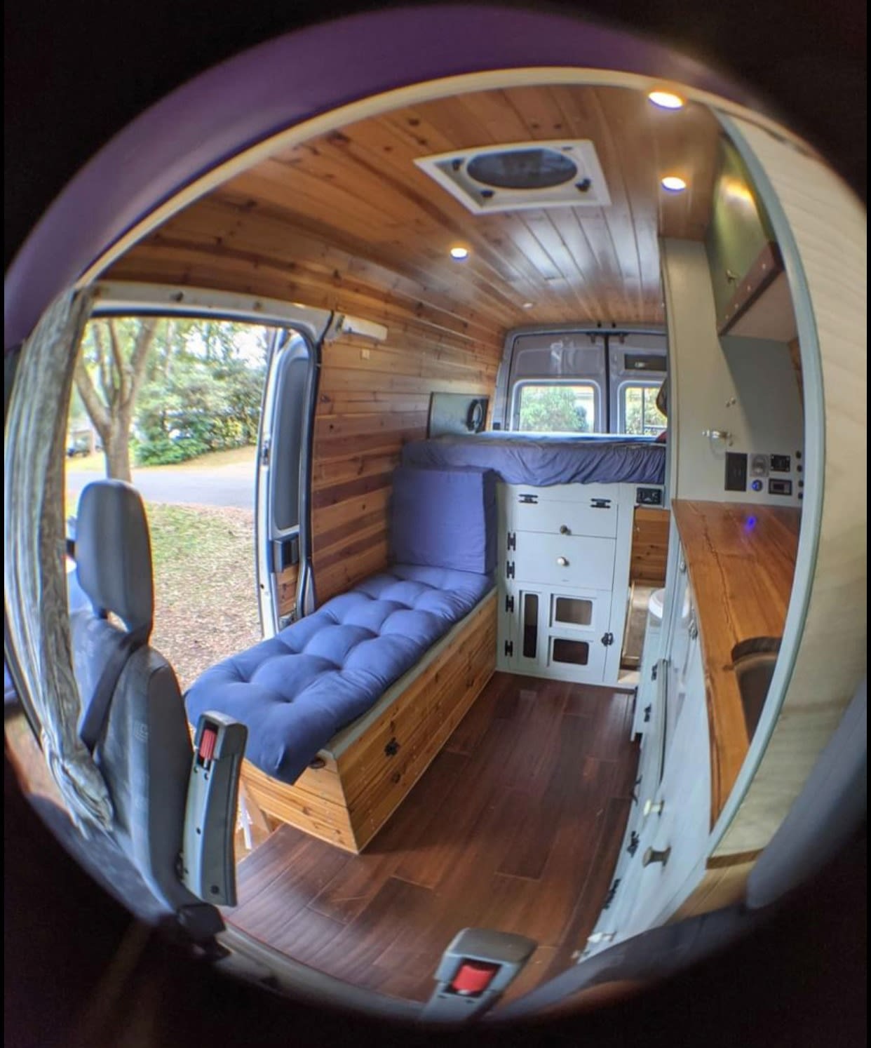 Explore van life with this RV rental! Cozy wood interior features a bed, comfy bench, and a compact kitchen setup.. Dodge Sprinter Van 2006