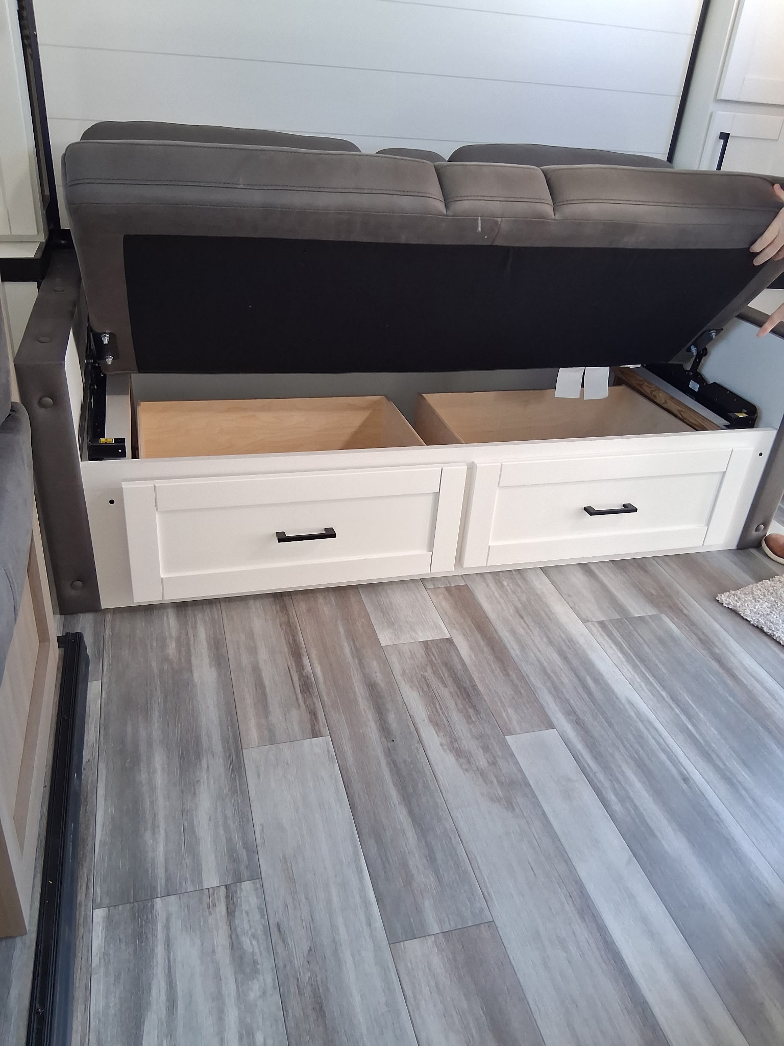 This RV rental's clever sofa lifts to expose deep under-seat storage and two drawers, perfect for optimizing compact living.. Oliver Travel Trailers Jay Fligh SLX 2026