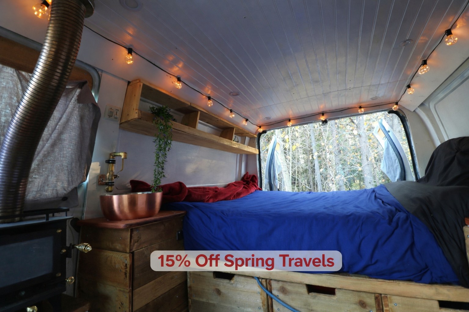 Inside a rustic RV rental: a bed, wood stove, copper sink, and string lights, with a forest view. Enjoy 15% off spring travels.. Ford Econoline 2012