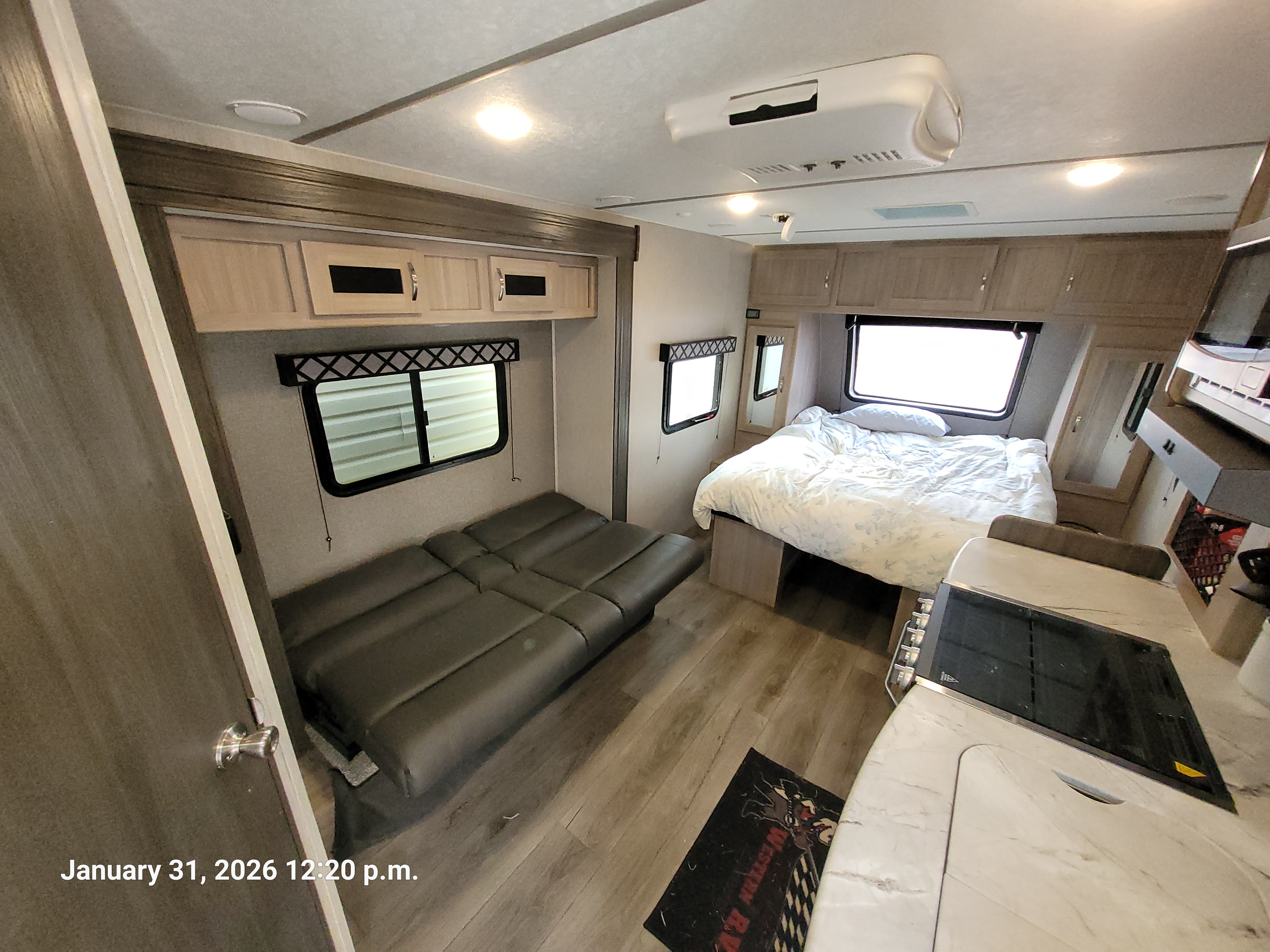Cozy RV rental interior with a comfortable bed, fold-out couch, and compact kitchen counter for travel.. Coachmen Freedom Express 192RBS 2021