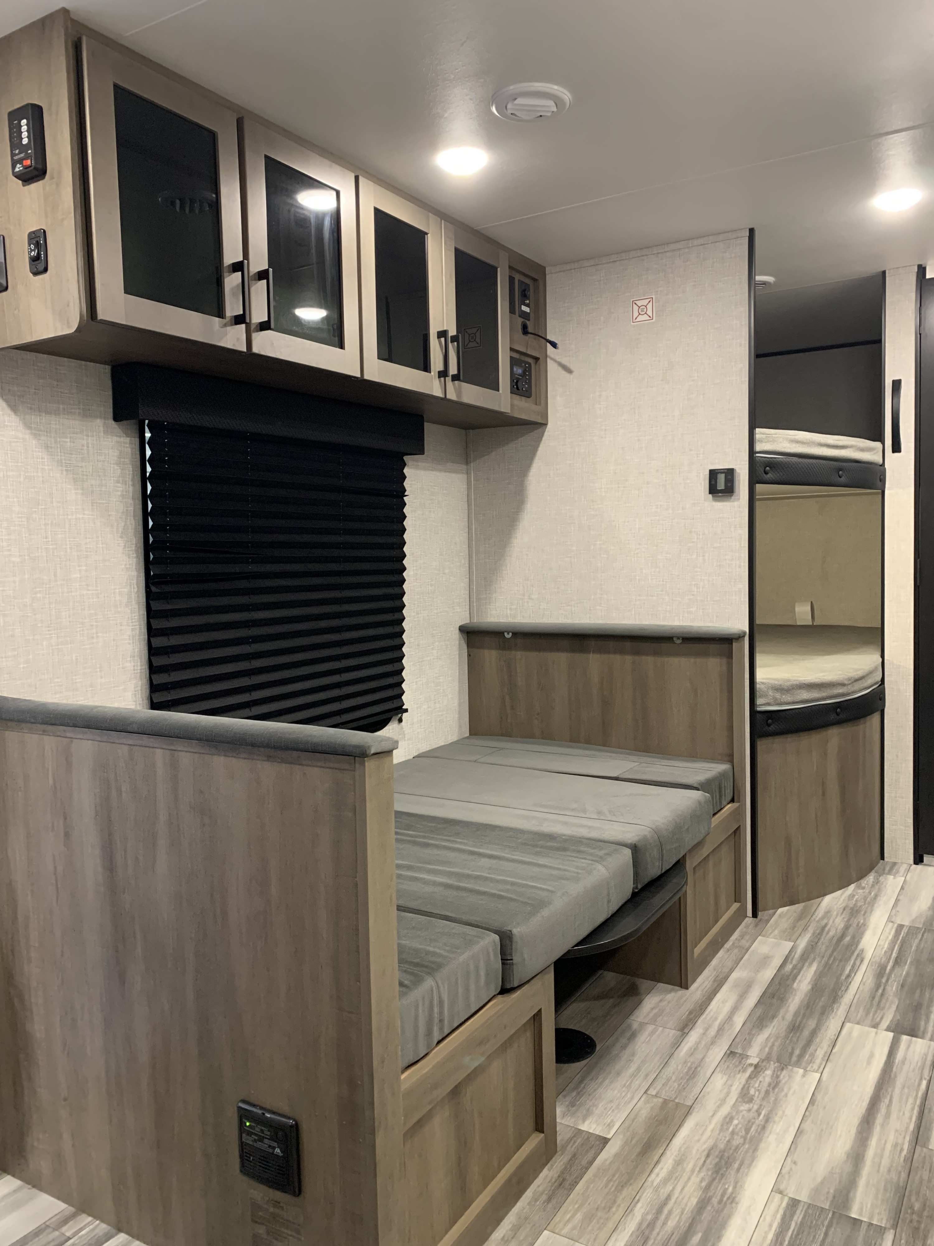 Cozy RV rental interior with a dinette that converts to a bed, overhead cabinets, and bunk beds visible.. Jayco Jay Flight SLX 2025